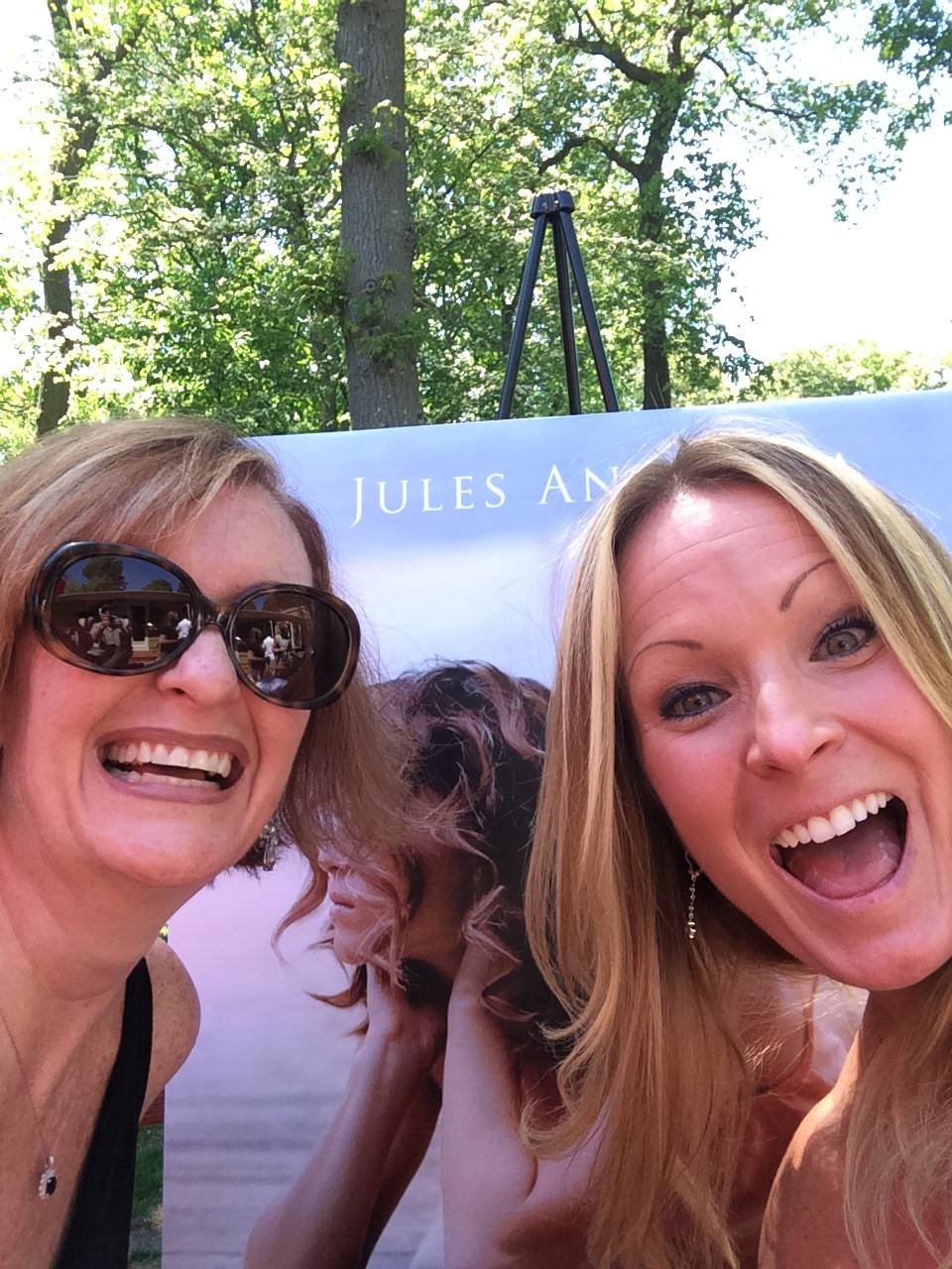 author with a female friend excited image of her book in large format the background