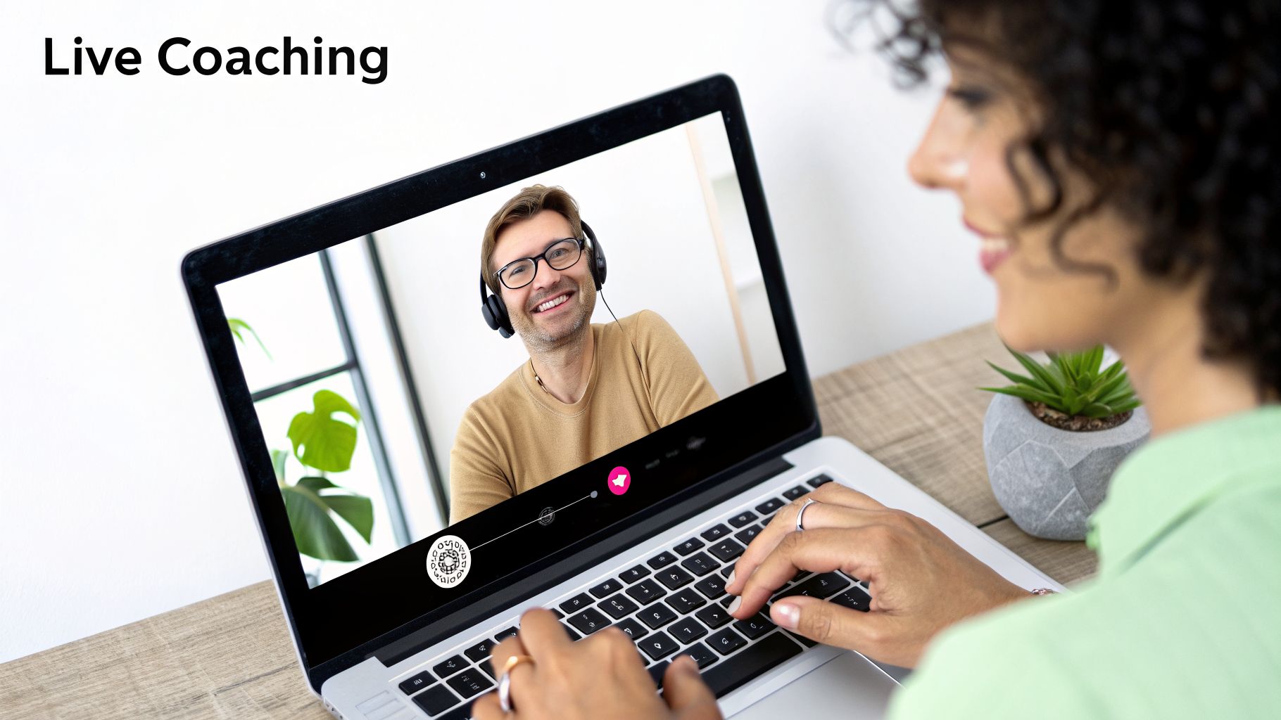 A woman receives live coaching via video call on her laptop from a smiling male coach.