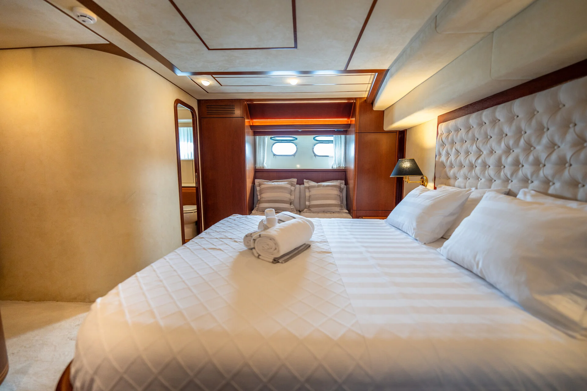 White Rock 36 speedboat with captain at helm cruising calm blue waters near Paros coastline with hills in background.