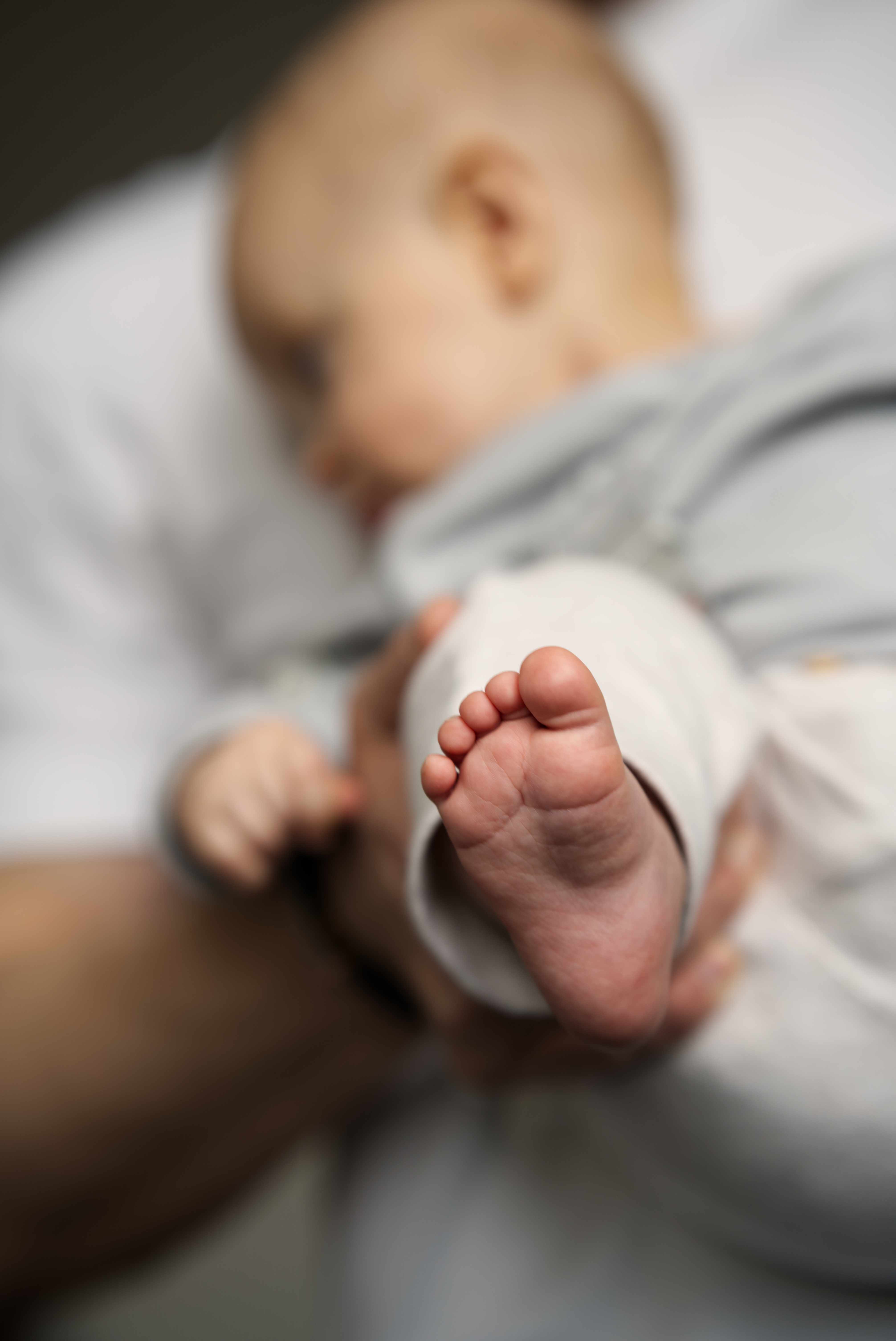 Newborn focení - miminko v náručí, detail nožičky