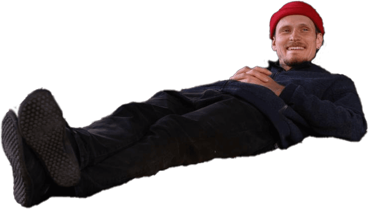 Man liyng on the floor wearing a red hat