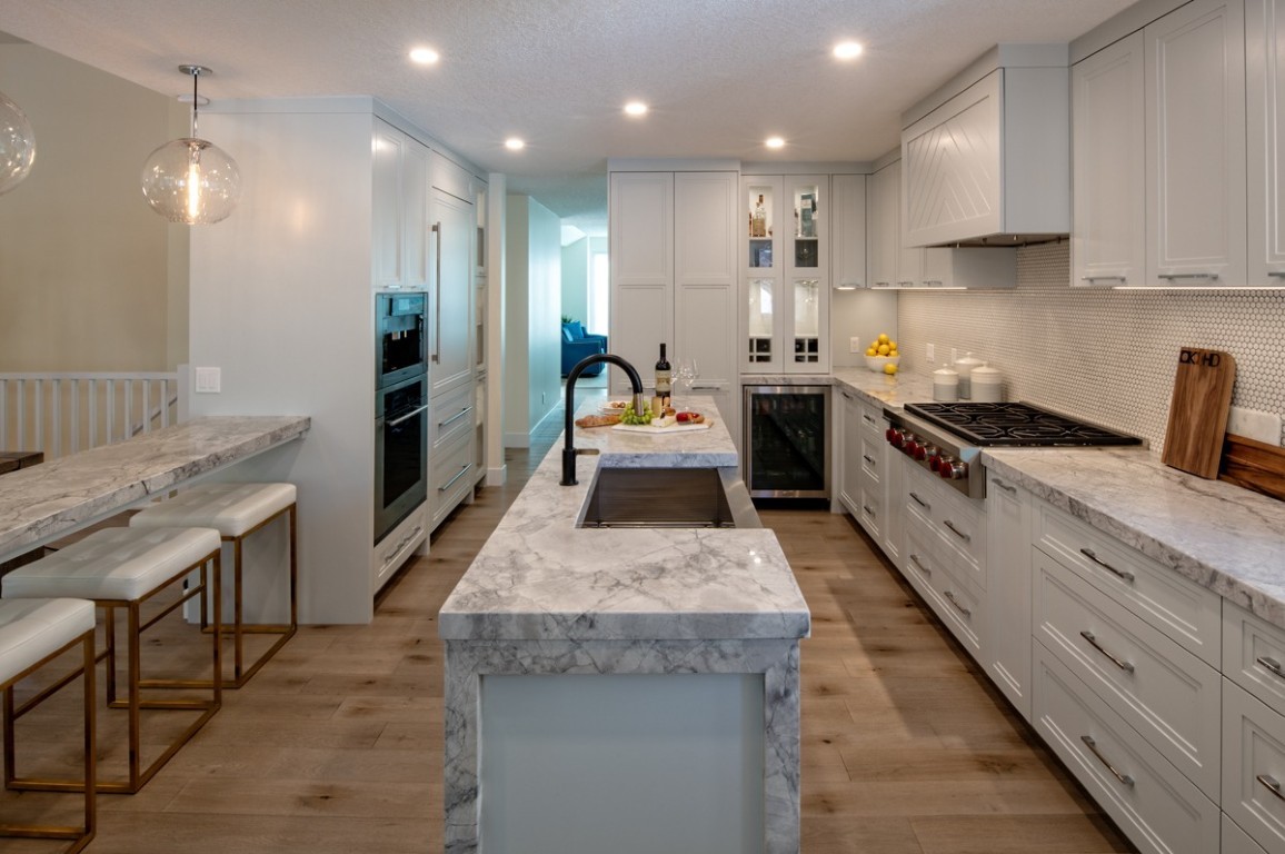 Image of Luxury kitchen design with marble countertops, white cabinets, and modern furniture by KHD Homes.