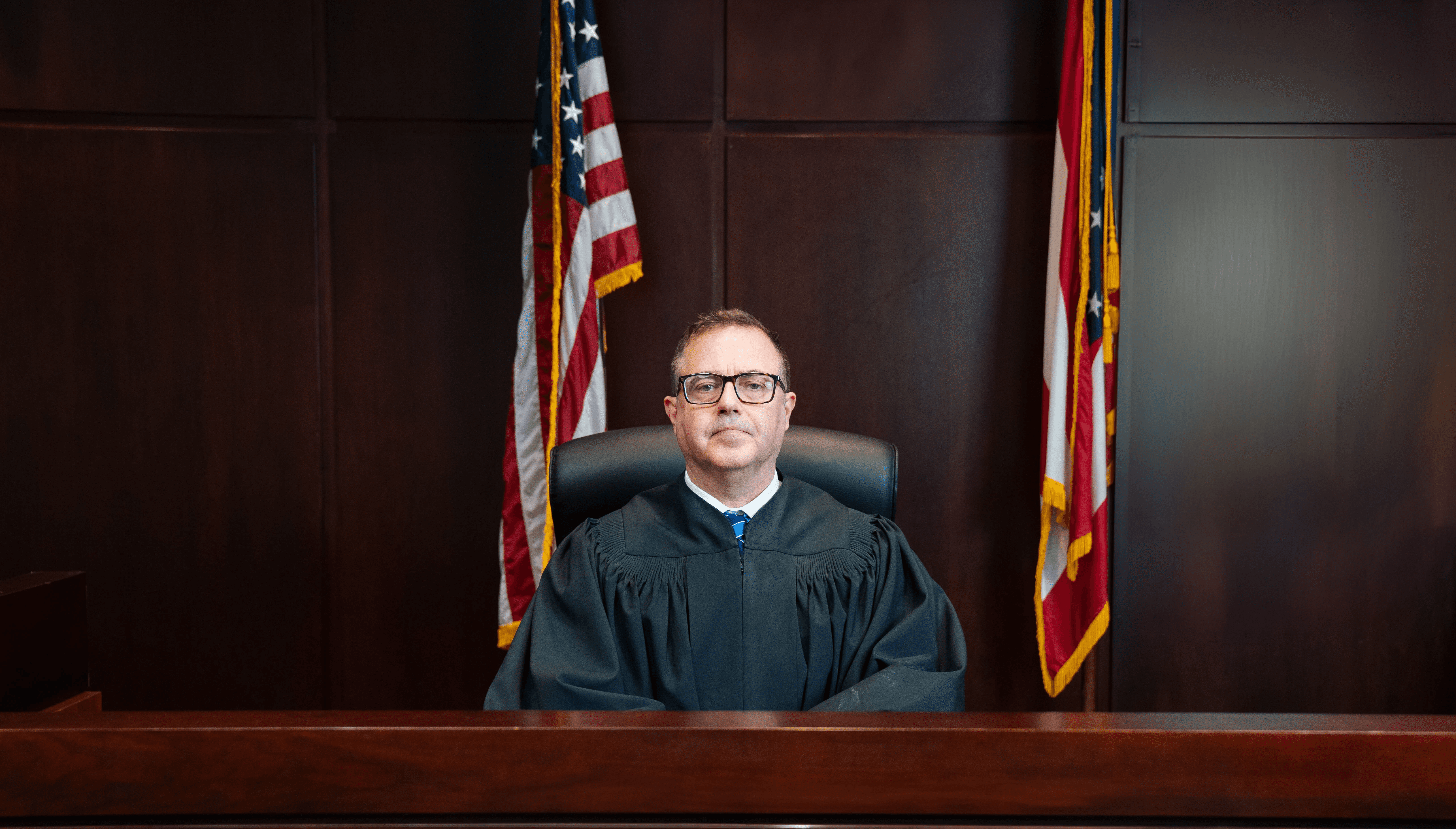 Magistrate Steven M. Abshire seated on the bench in judicial robes beneath the Great Seal of Ohio