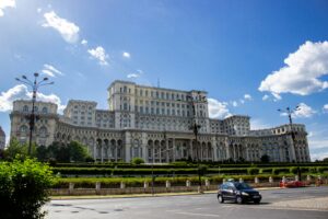Grand neoclassical facade of the Palace of the Parliament in Bucharest, Romania, captured under a clear blue sky