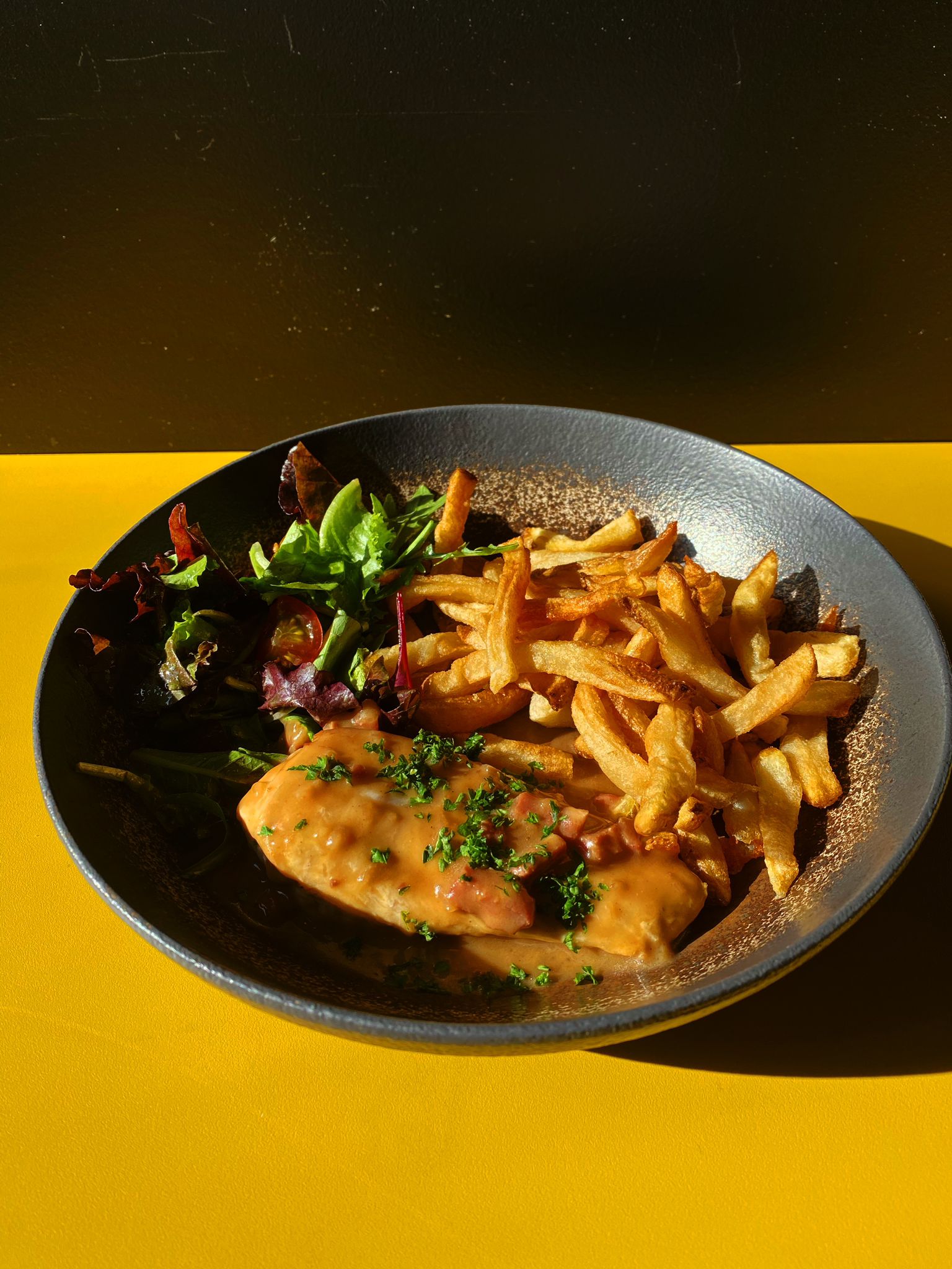 Poulet rôti flambé avec flamme accompagné de frites au gras de boeuf et d'un verre de vin rouge dans un restaurant