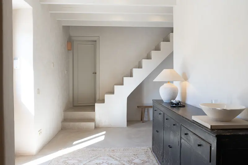 Interior casa escaleras y puerta al fondo