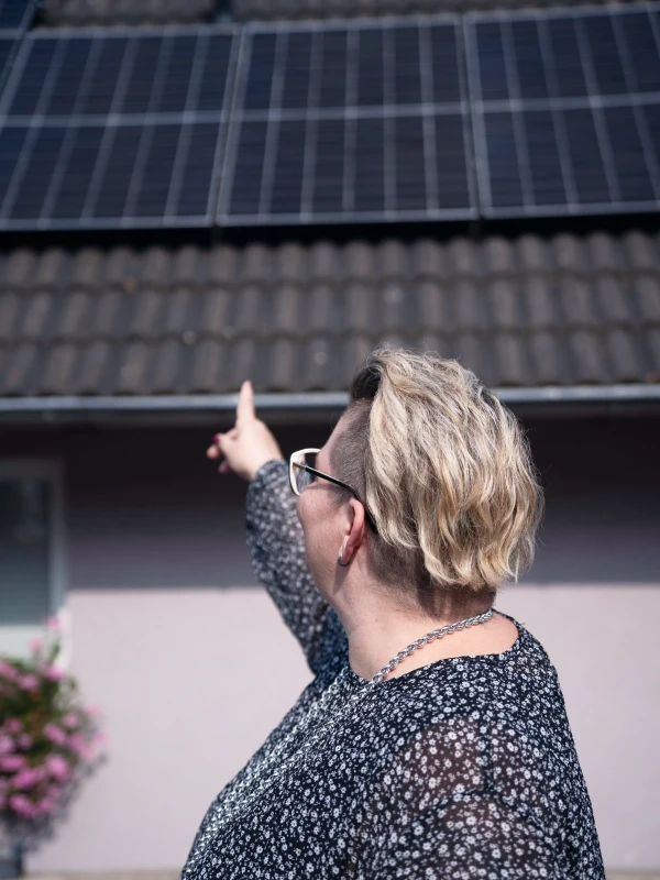 Eigentümerin Riedesel-Nüßgen zeigt auf die fertig installierte PV-Anlage auf ihrem Dach