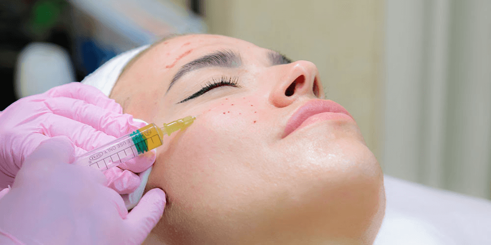 Woman undergoing VISIA Skin Analysis with advanced imaging device that captures high-resolution facial scans to evaluate skin texture, pigmentation, and underlying concerns.