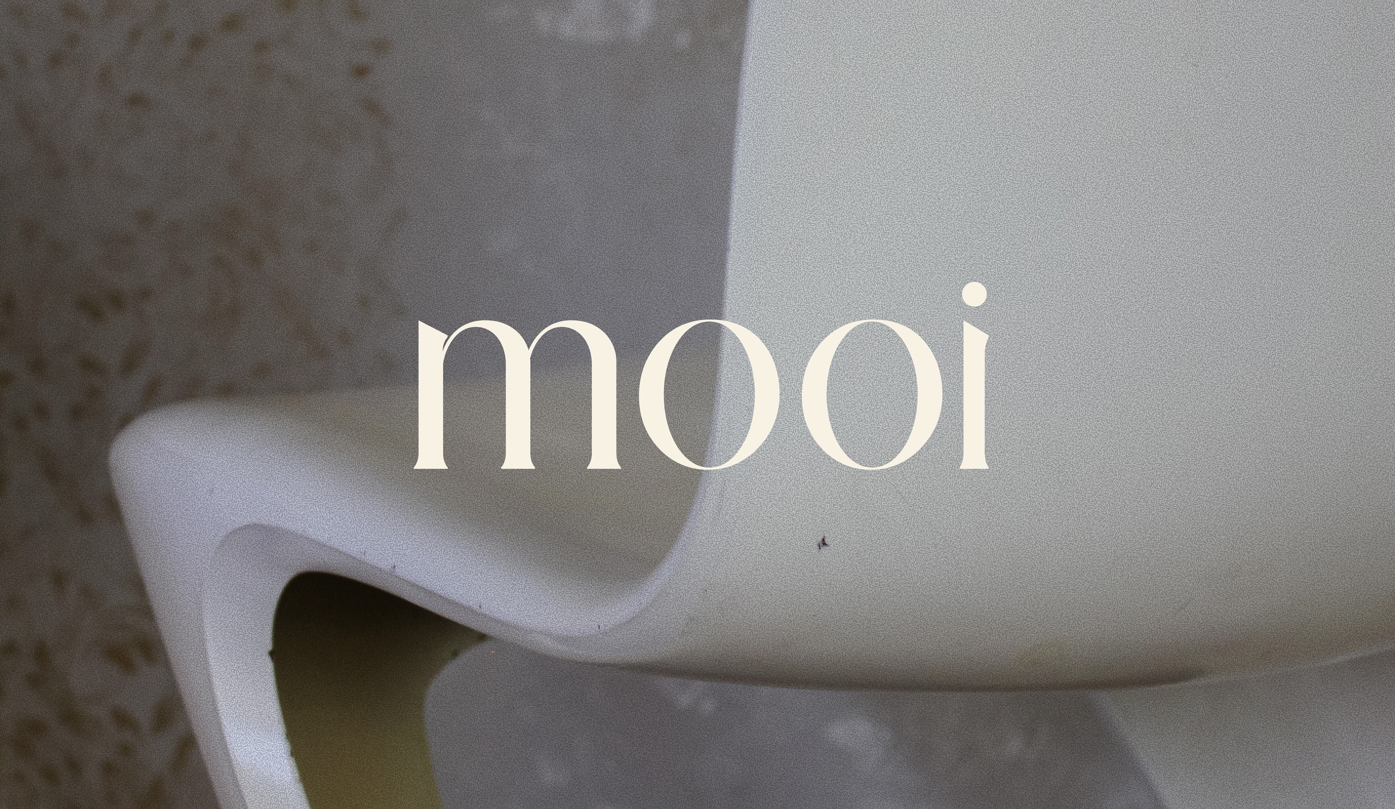 Logo „mooi“ über einer skulpturalen weißen Sitz- oder Möbelgestaltung.