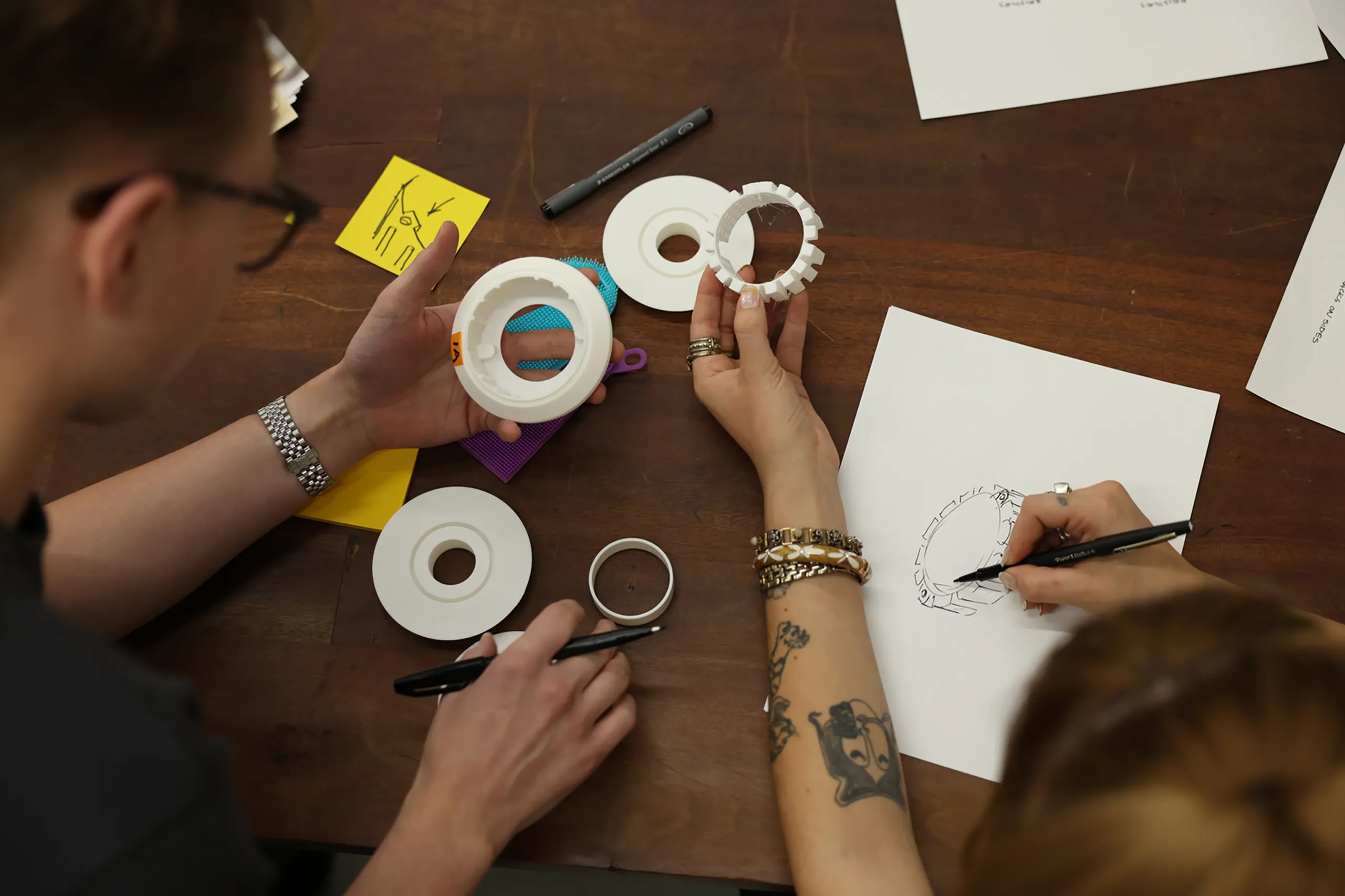 Hands building physical product prototypes with tape and workshop tools