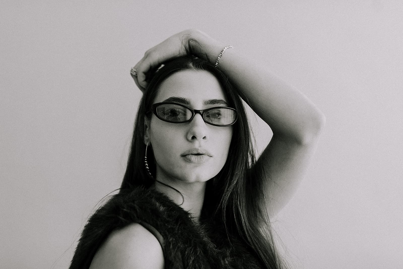 A close-up of a model wearing black sunglasses, softly lit by natural light in Revelator Studio, a premier photography studio in Shreveport.