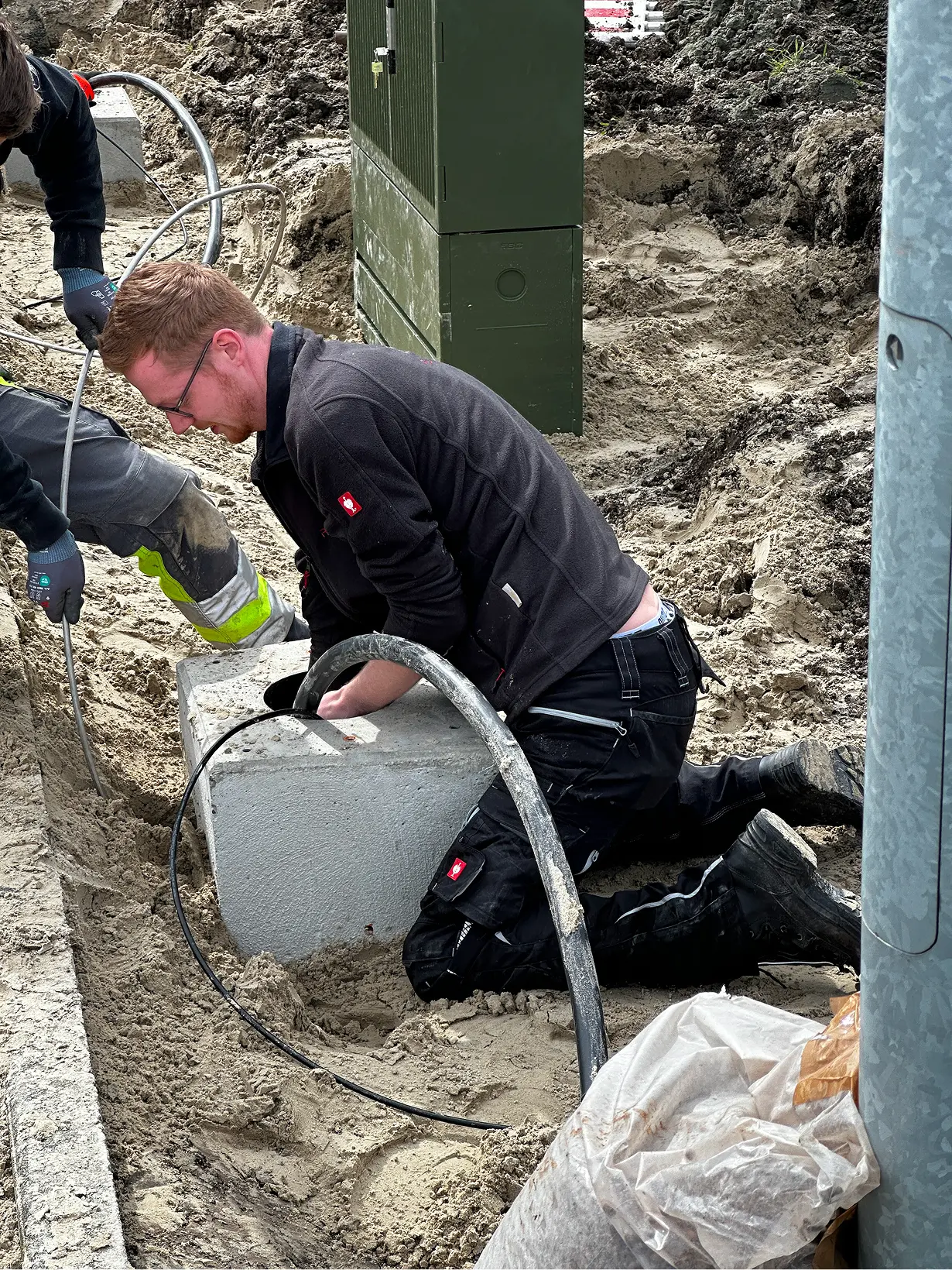 Mitarbeiter verlegt Kabel für eine Ladesäule