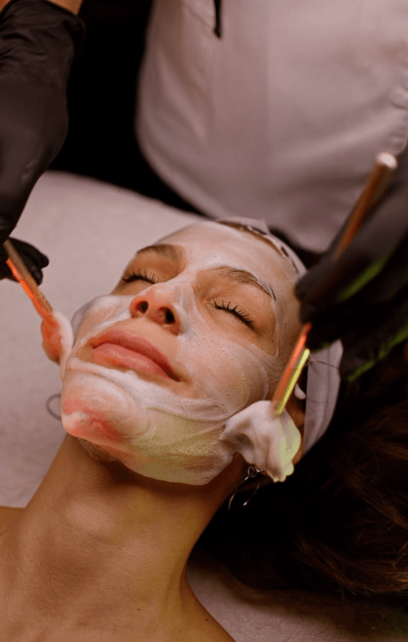 Cosmetologist performing a facial treatment on a relaxed client in a spa setting