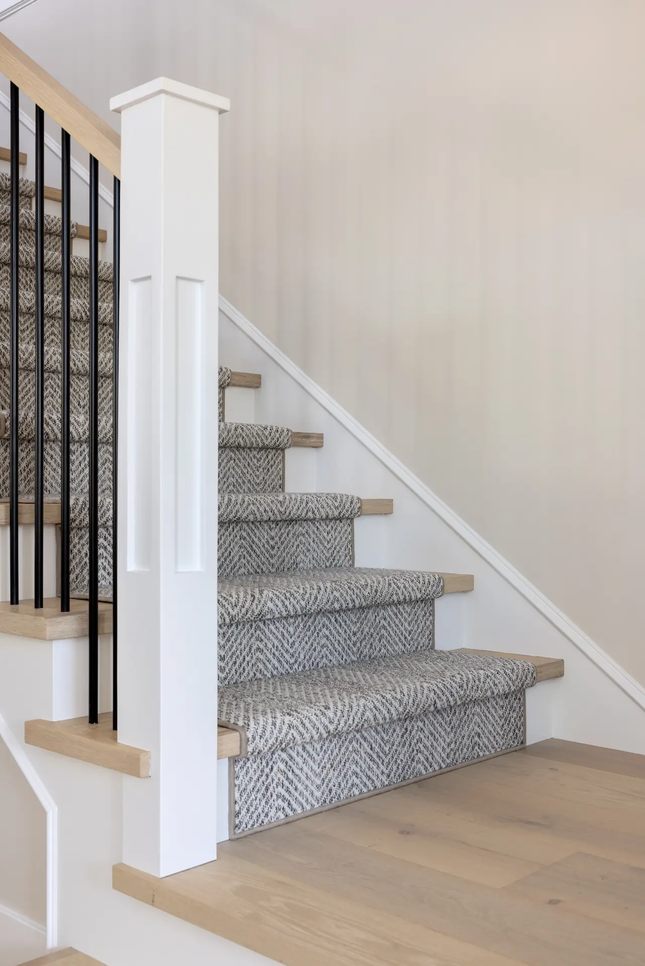 Portrait of the bottom floor staircase landing in the Irvine Contemporary Coastal Remodel. Photo by Molly Rose Photography.