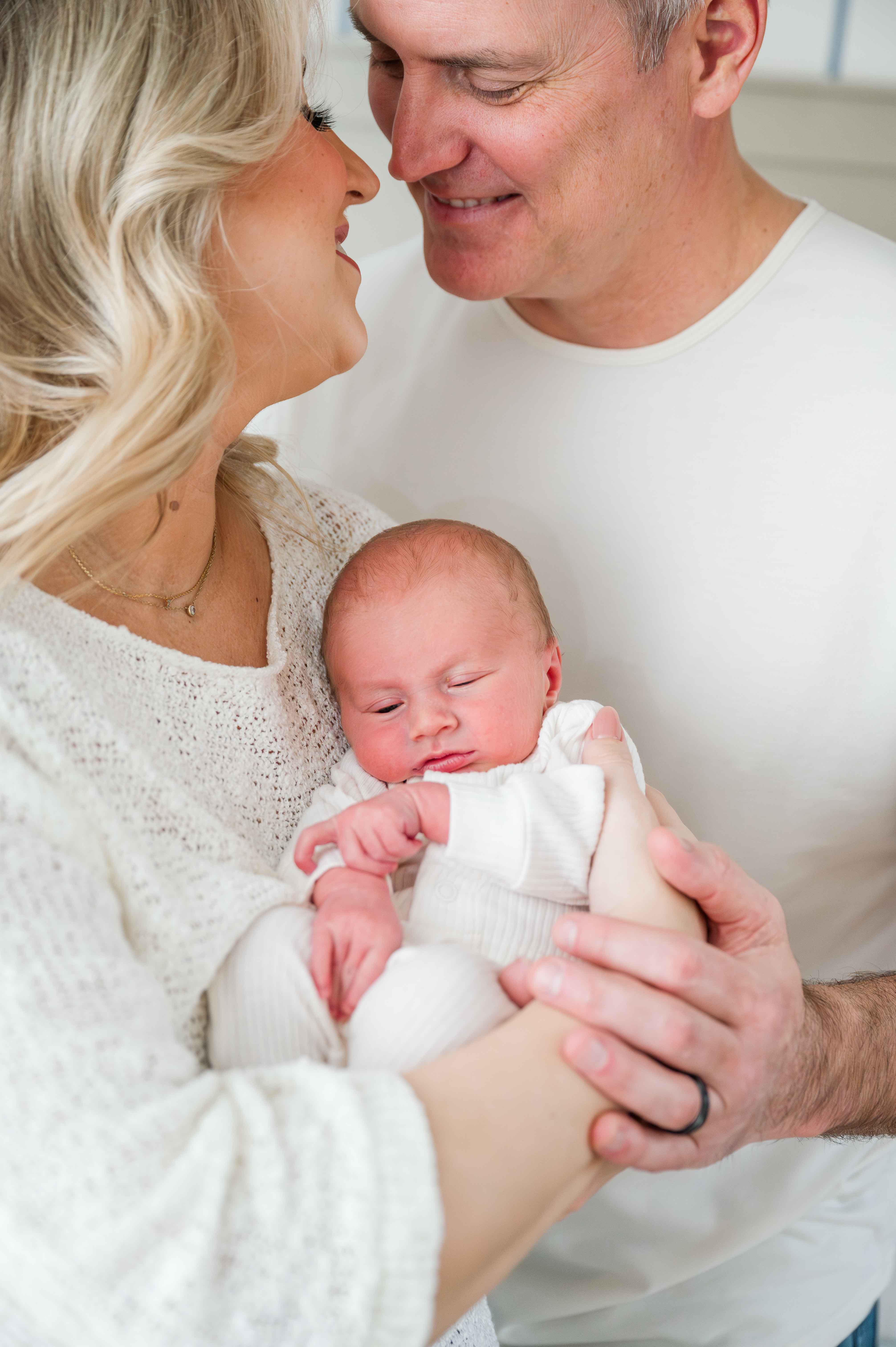 Lifestyle newborn session of parents holding newborn baby.