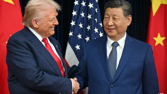Donald Trump and Xi Jinping shaking hands, flags behind them.