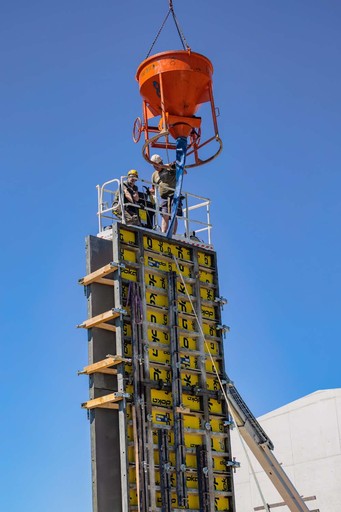 Bauarbeiter füllen Säule mit Beton