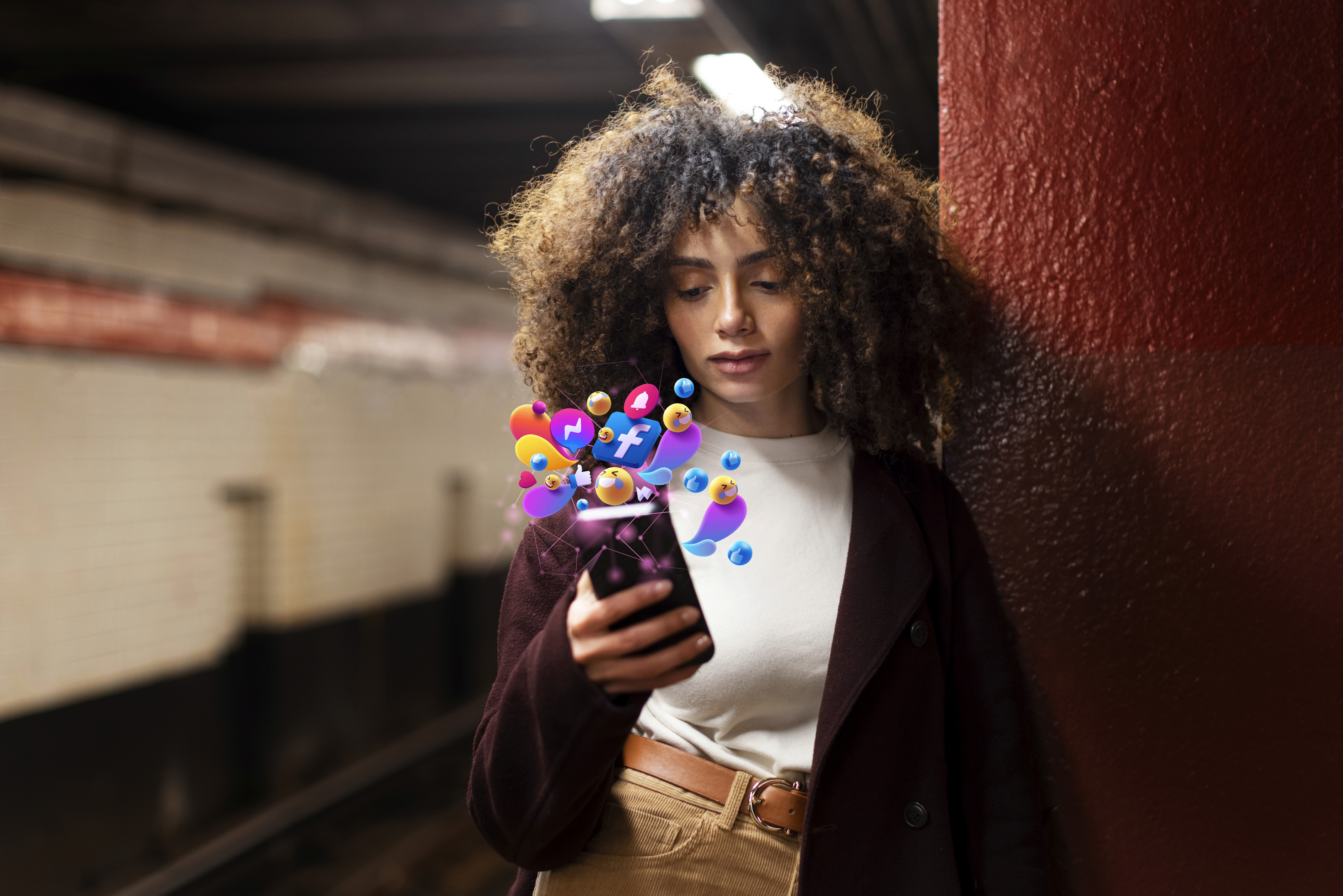 Analista de Social Media fazendo publicações nas redes sociais. Foco no celular com representação holográfica de ícones das redes sociais saindo da tela do dispositivo. 