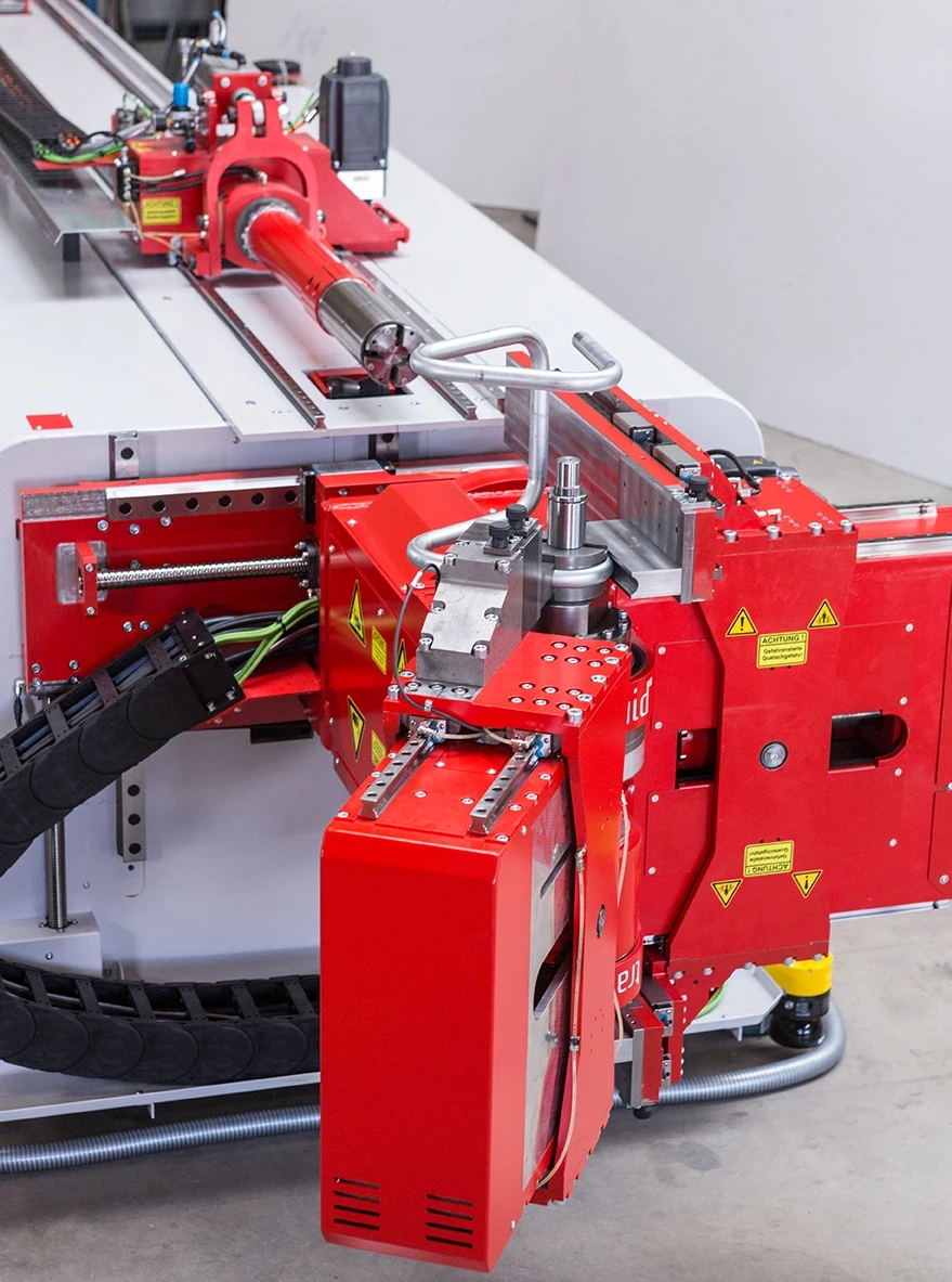 Automated tube bending machine shaping metal tubing with precision tooling.