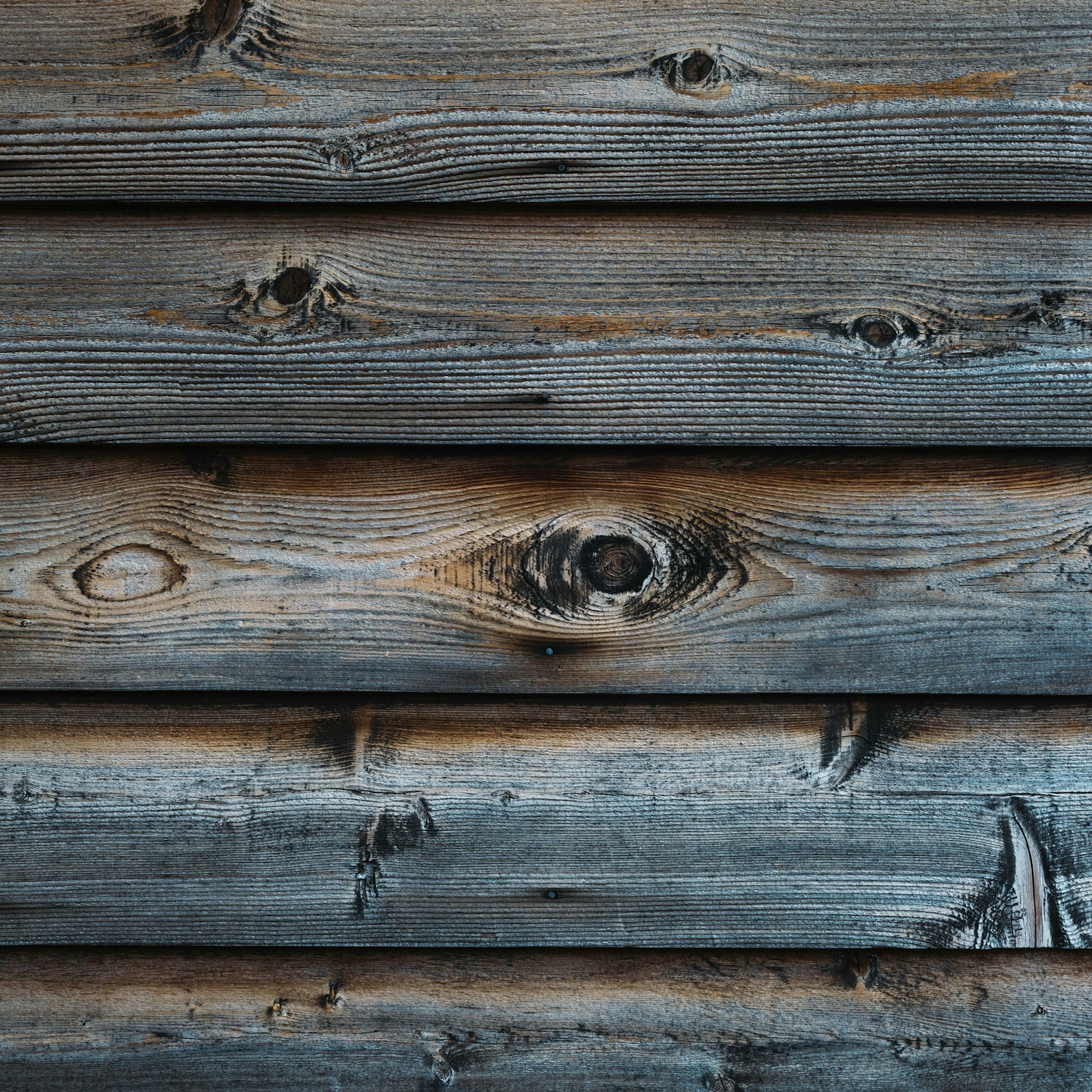 Weathered horizontal timber boards with knots and silver grain