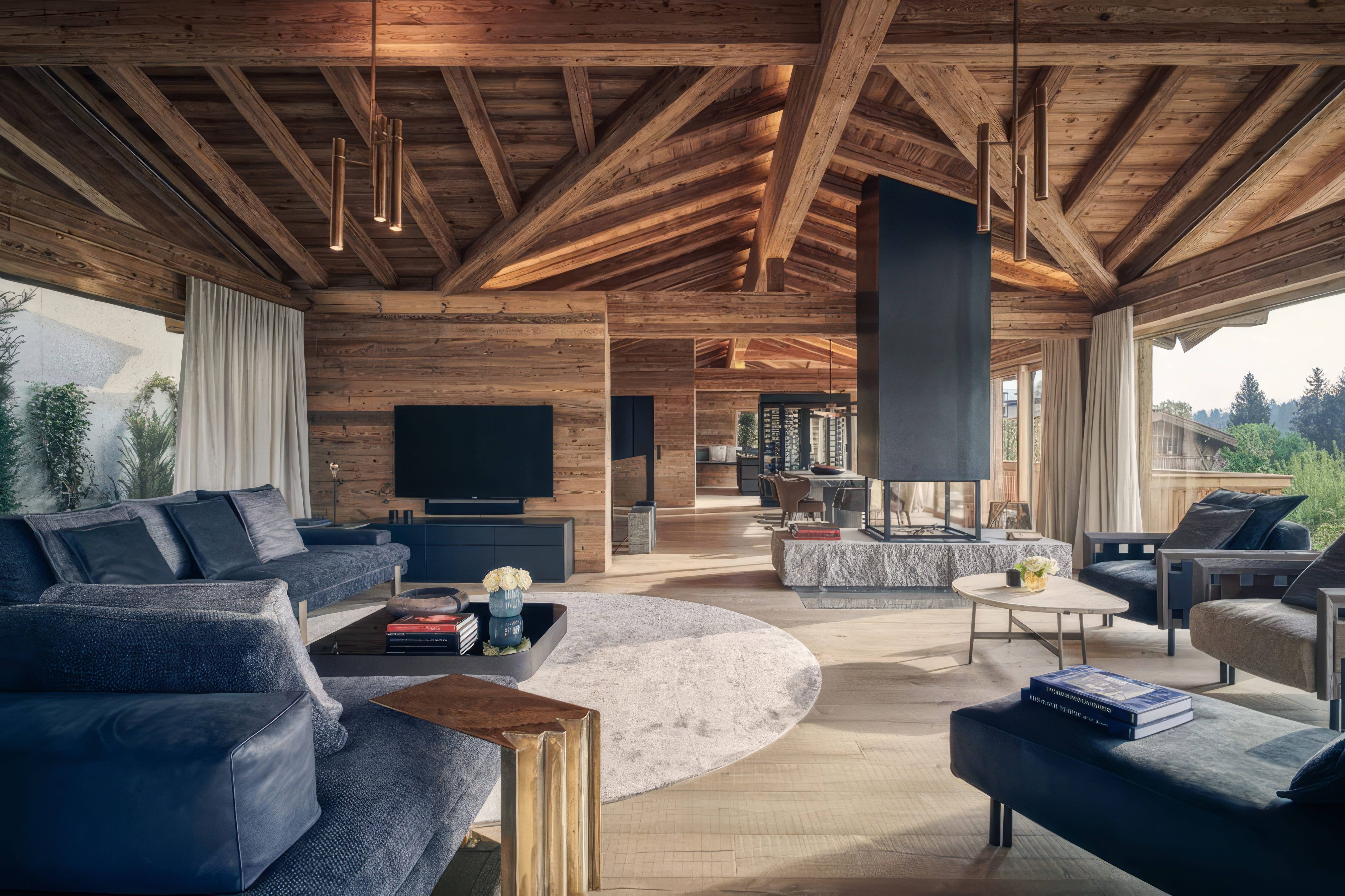 MW Interior Hoteleinrichtung – rustikaler Chalet-Wohnbereich mit Holzbalkendecke, TV-Wand und gemütlicher Sofagarnitur