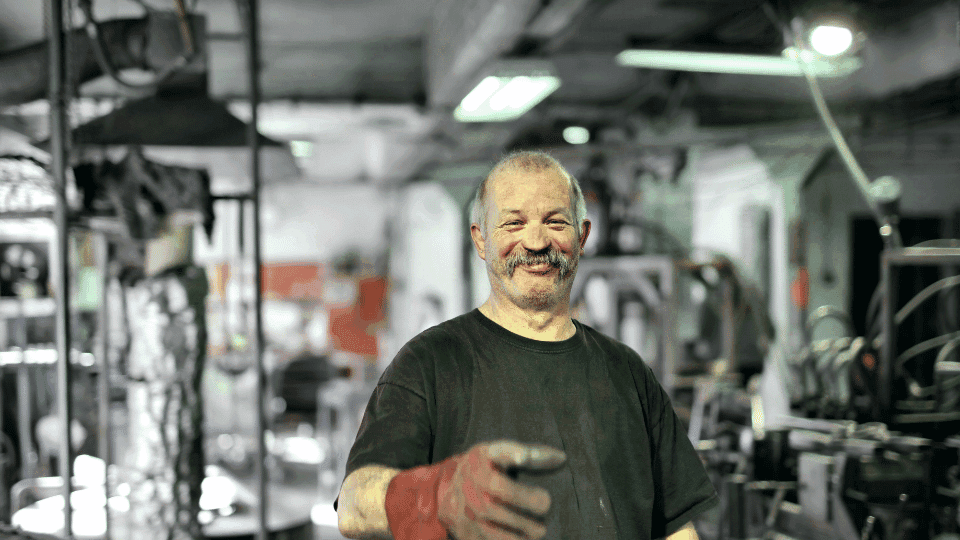 An senior mechanic offering a handshake