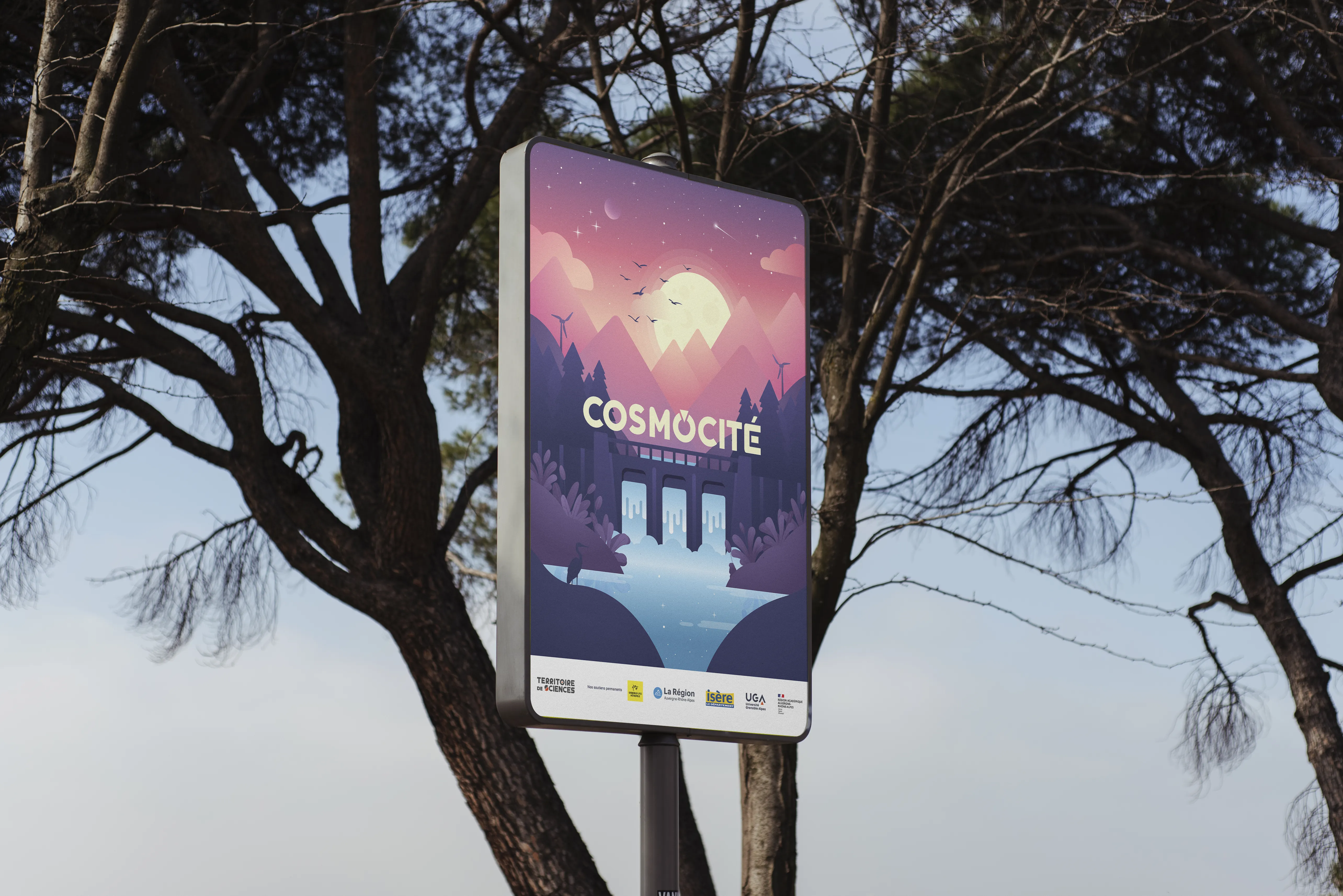 Un panneau publicitaire numérique affichant une illustration colorée intitulée Cosmocité, installé au milieu d’un parc arboré.