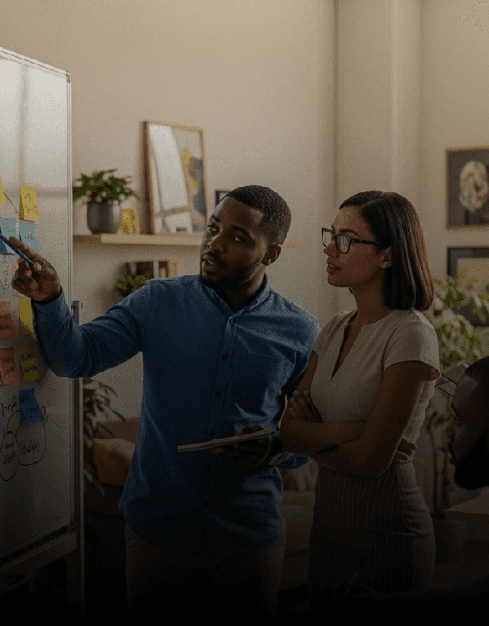 Man and woman pointing at whiteboard