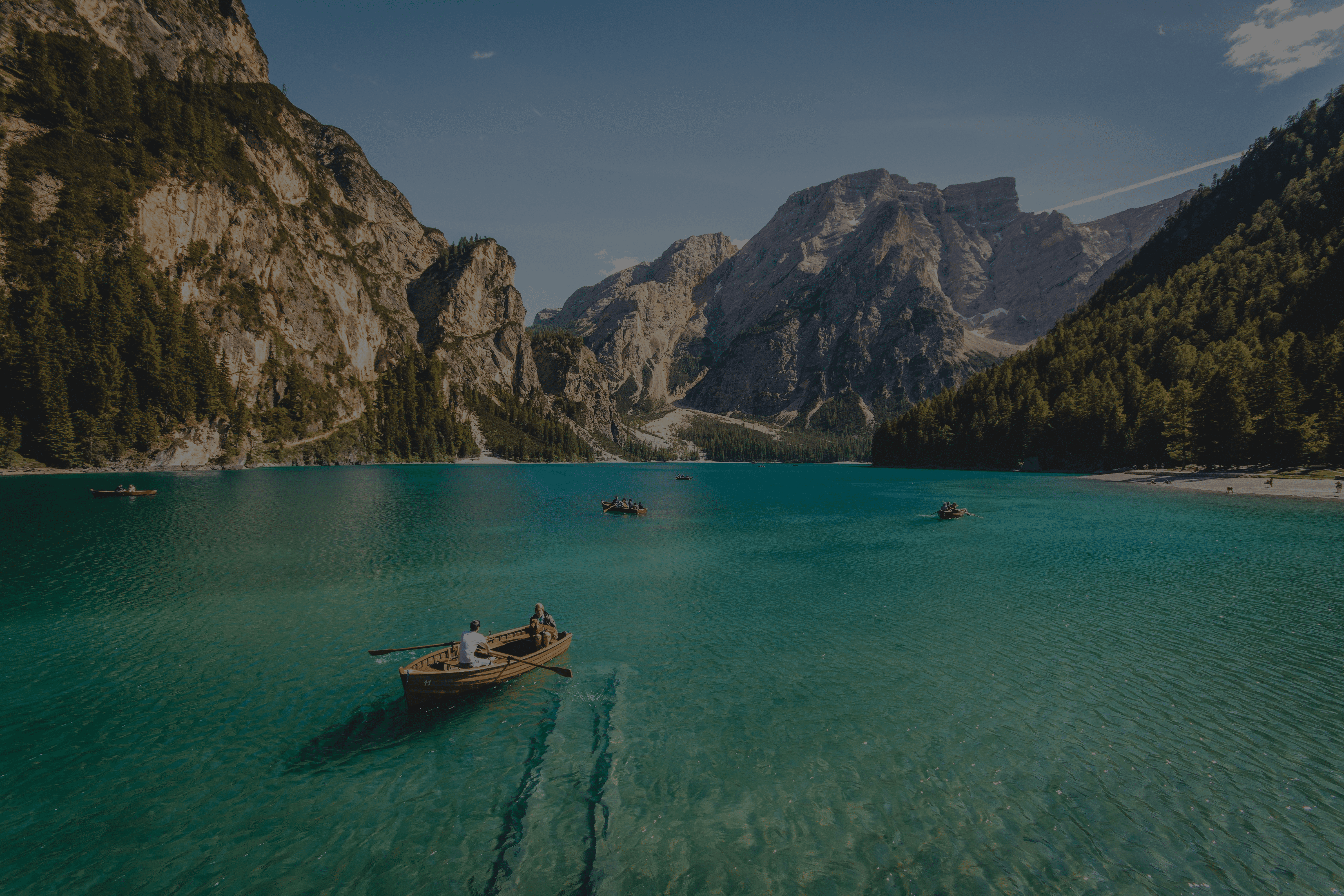 three brown wooden boat on blue lake water taken at daytime
