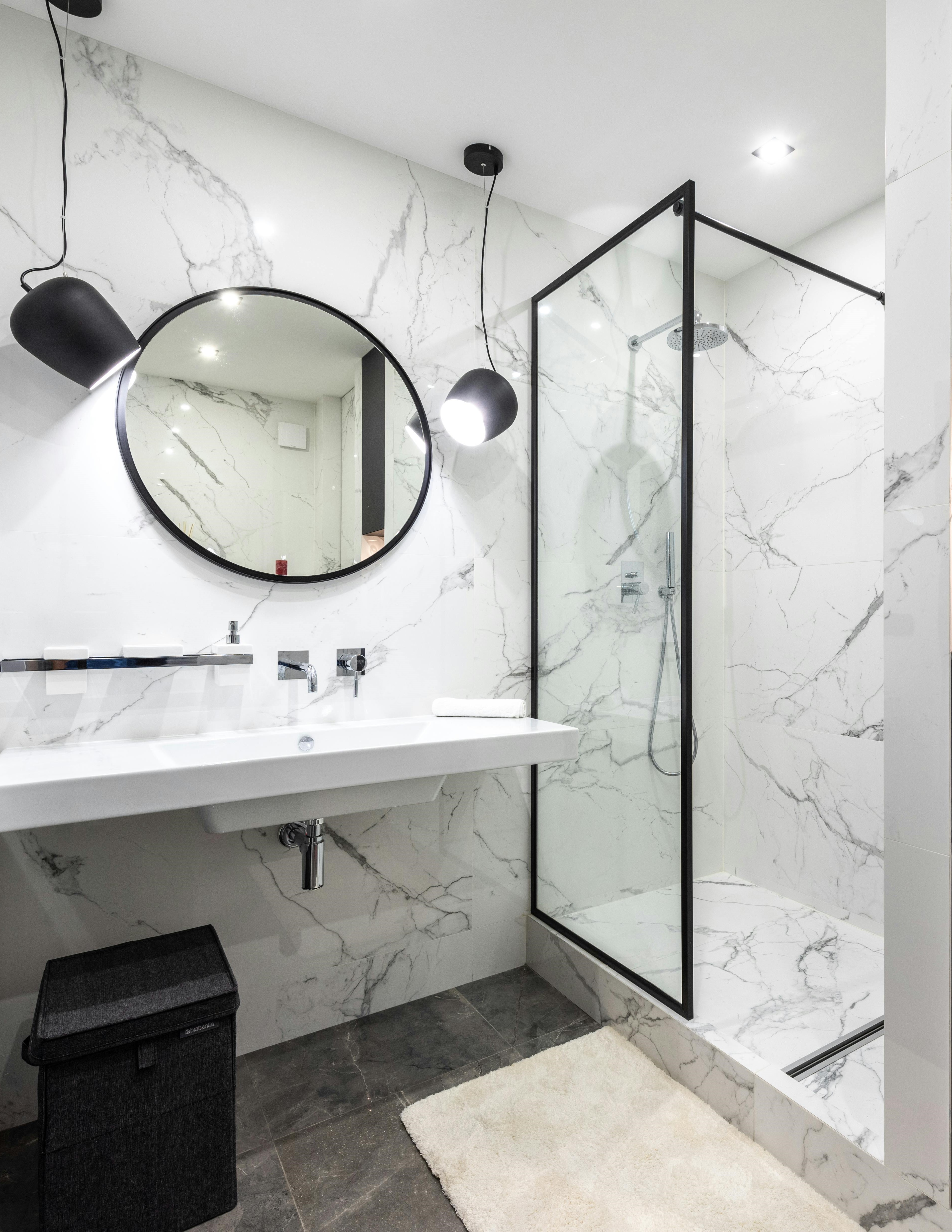 Modern living room with abstract art, beige sectional sofa, indoor plants, and large windows.