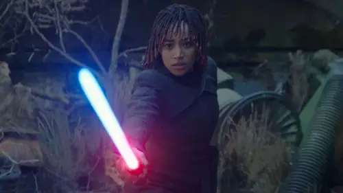 Osha Aniseya holding a lightsaber in front of her that is actively turning from blue to red