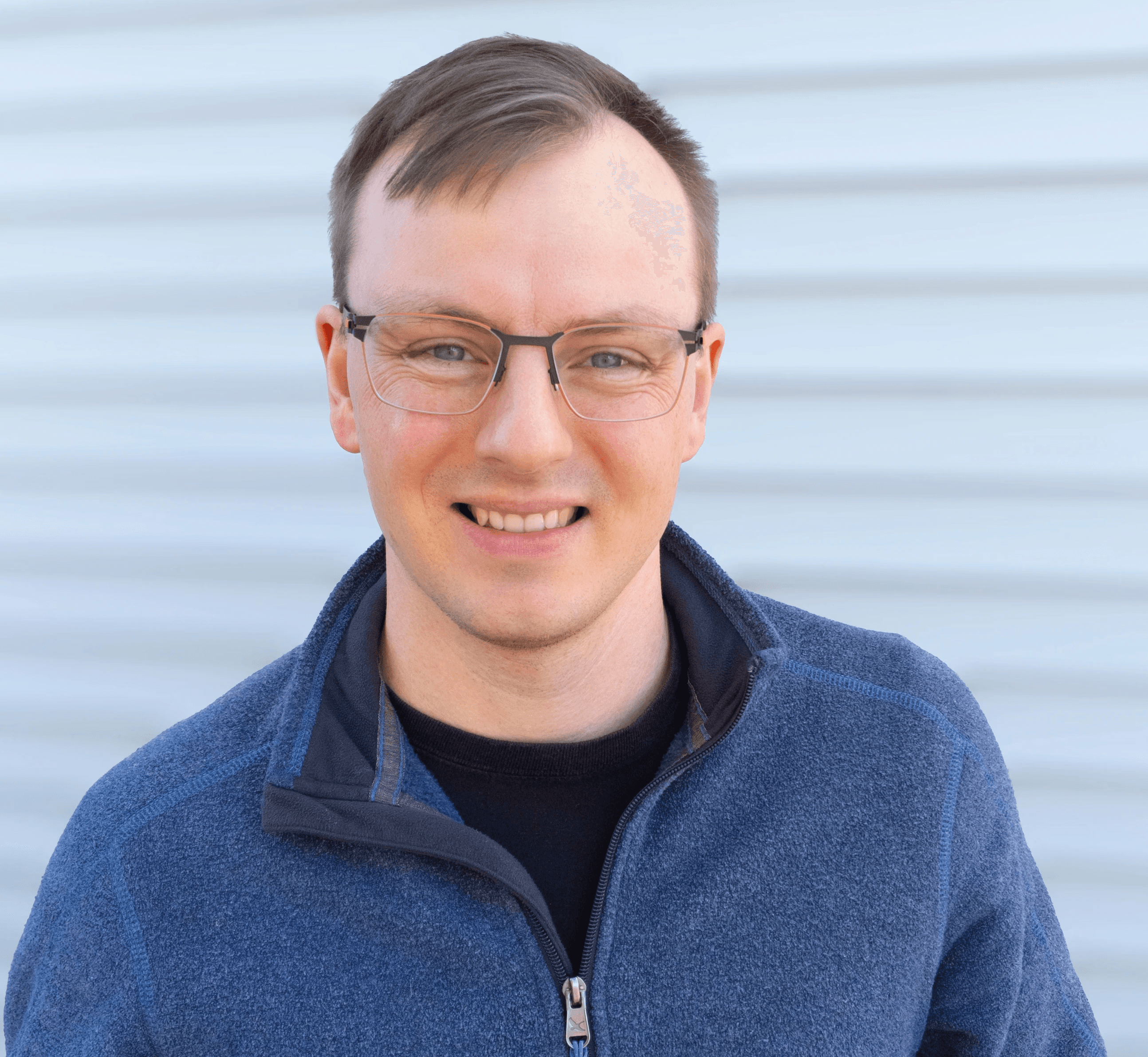 Smiling young man with glasses, short hair