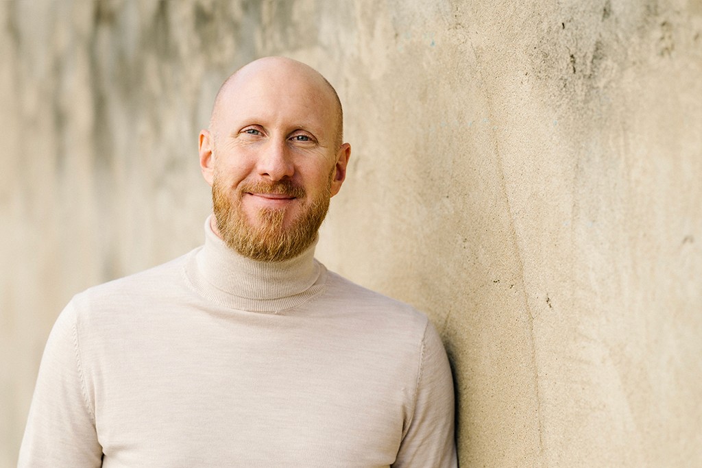 Sven Lamberty Portrait vor einer beigen Betonwand