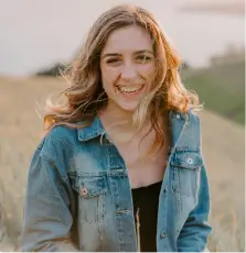 smiling woman sitting on grass during daytime