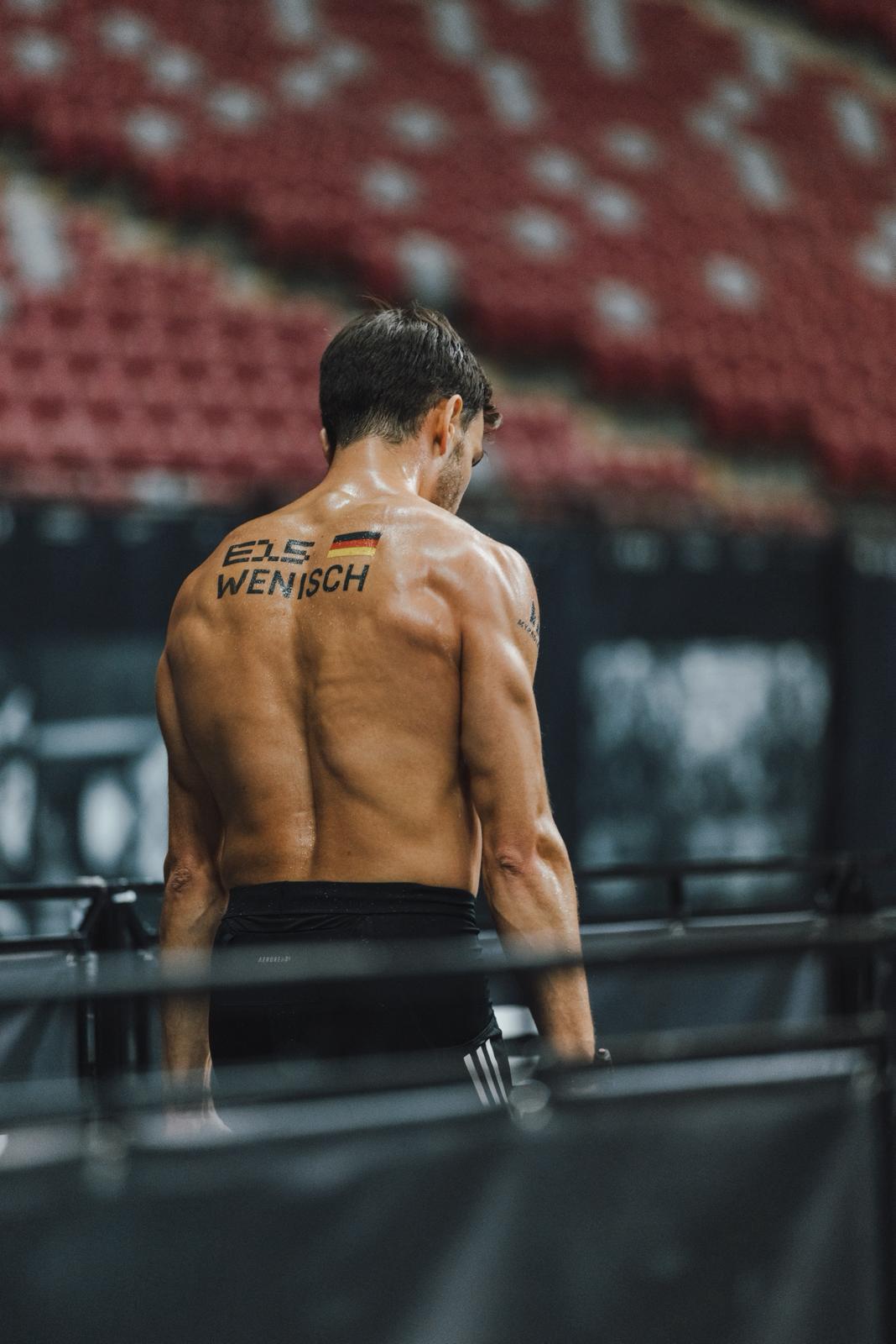 two men riding motocross bikes on brown sand