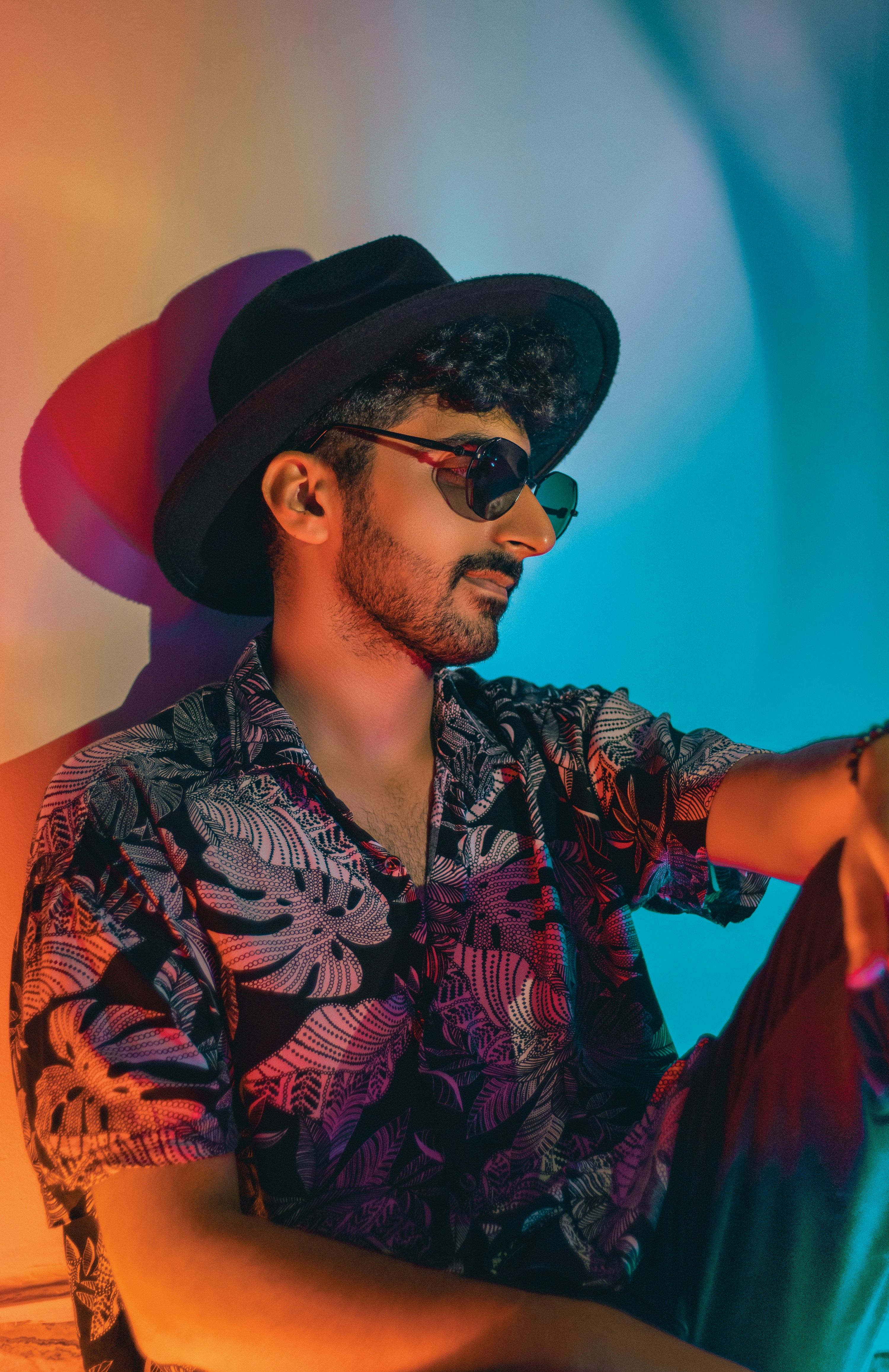 a man with a hat and sunglasses sitting down