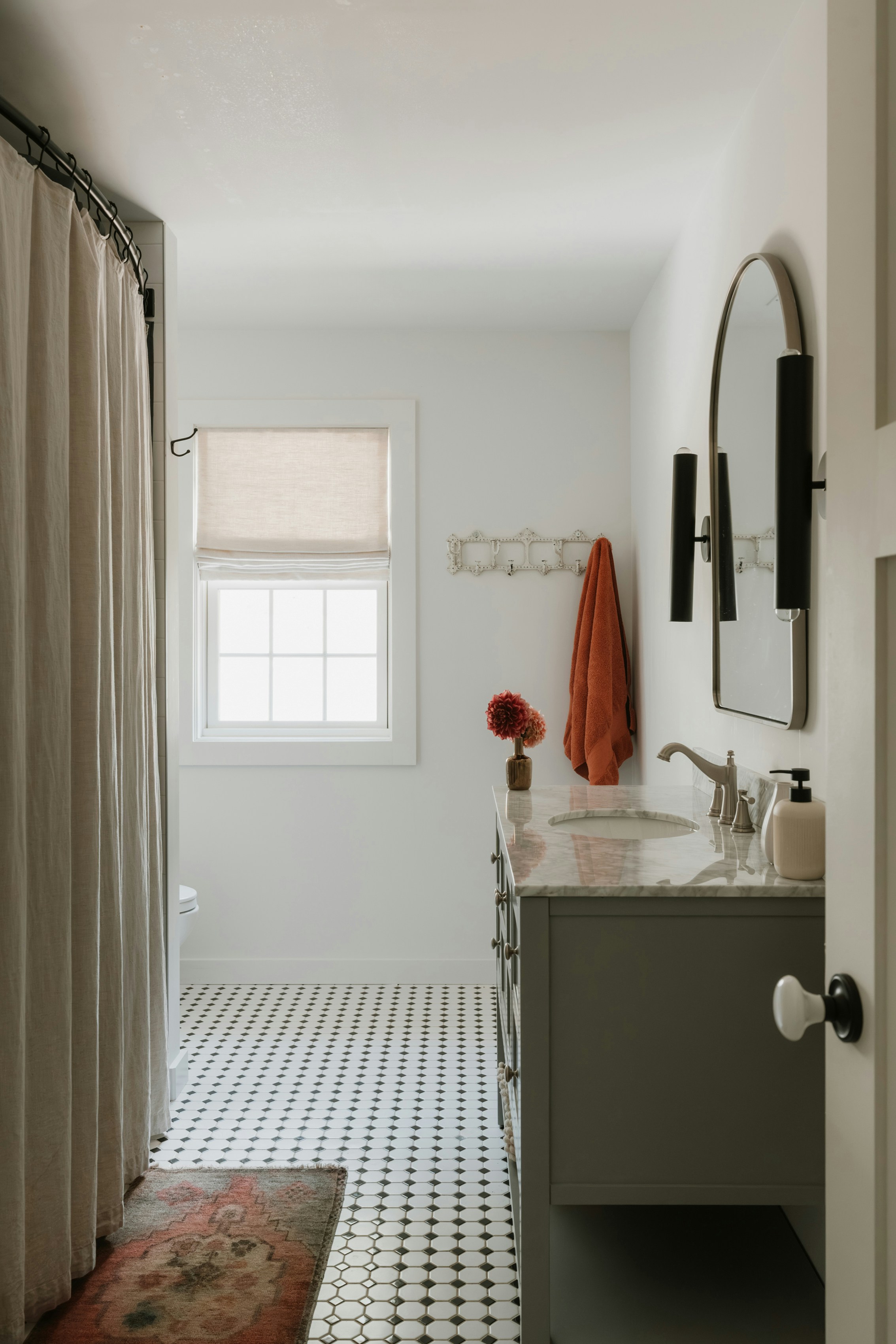 A modern bathroom with a vanity and tiled floor.