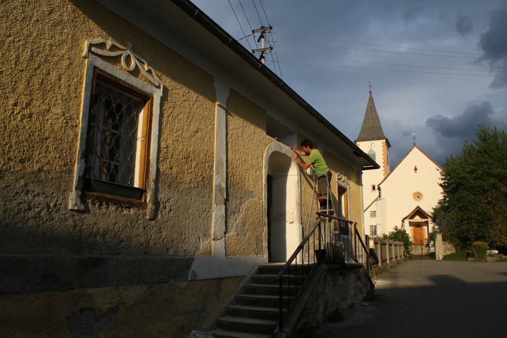 Haus Gelb von außen mit Person die arbeitet