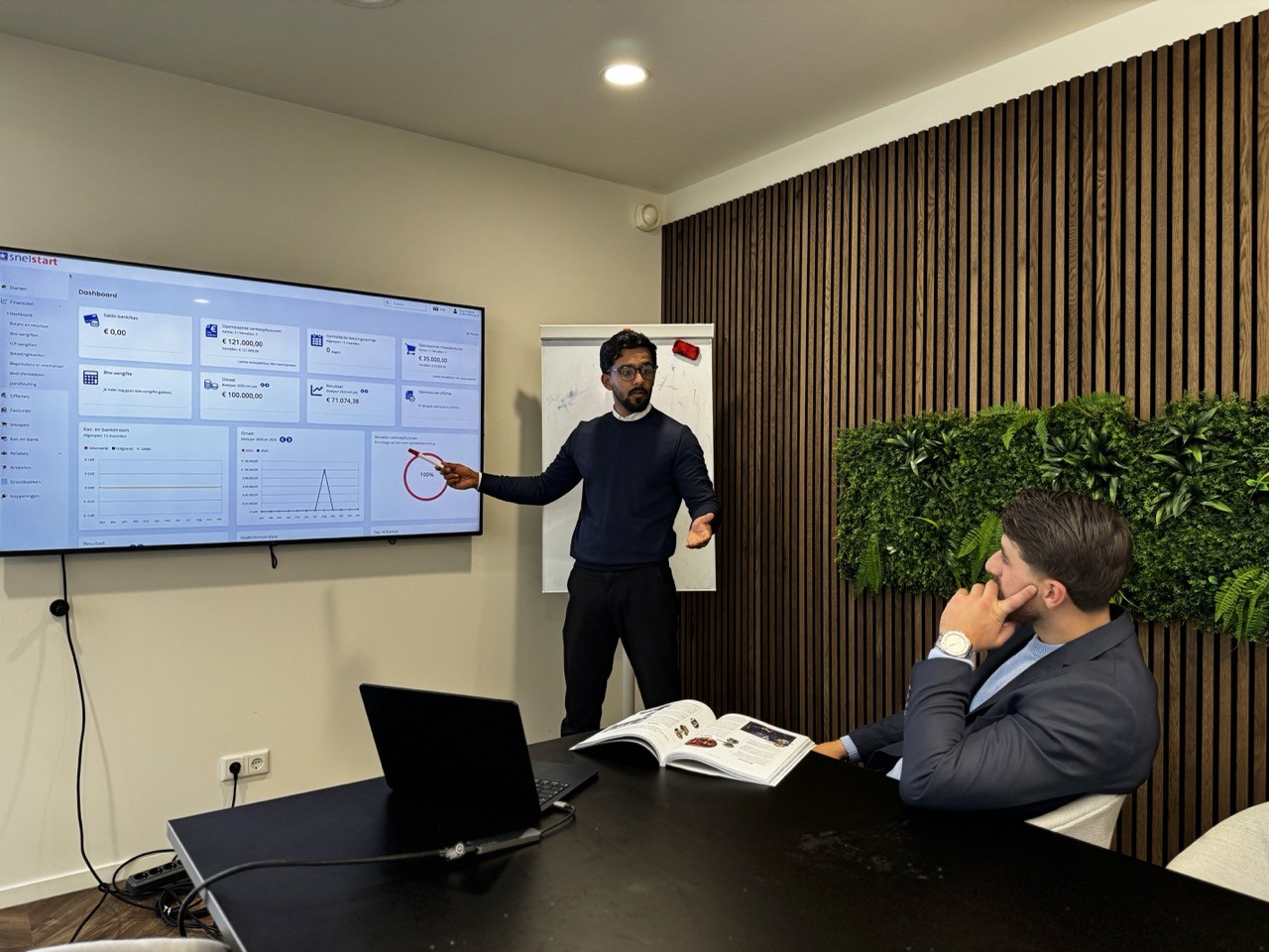 Twee financieel adviseurs in overleg bij raam – persoonlijke samenwerking en advies in een professionele setting