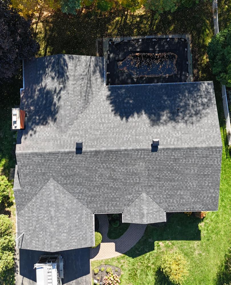 Vue aérienne d’une toiture résidentielle en bardeaux d’asphalte avec faîtages et sorties de ventilation visibles