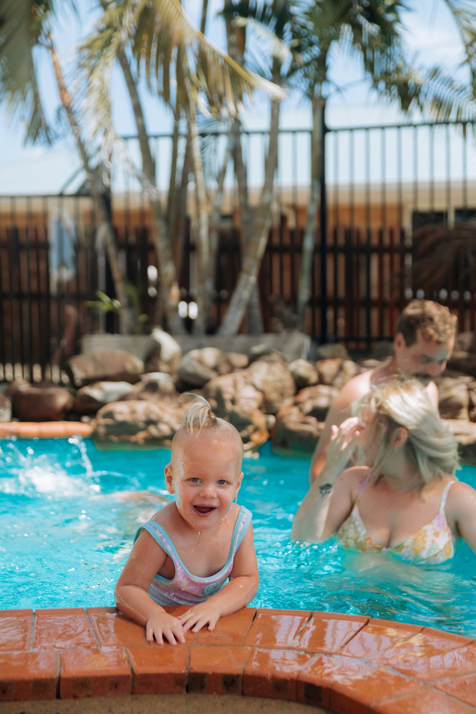 Family swimming in the pool in relaxed in-home family session in Mackay
