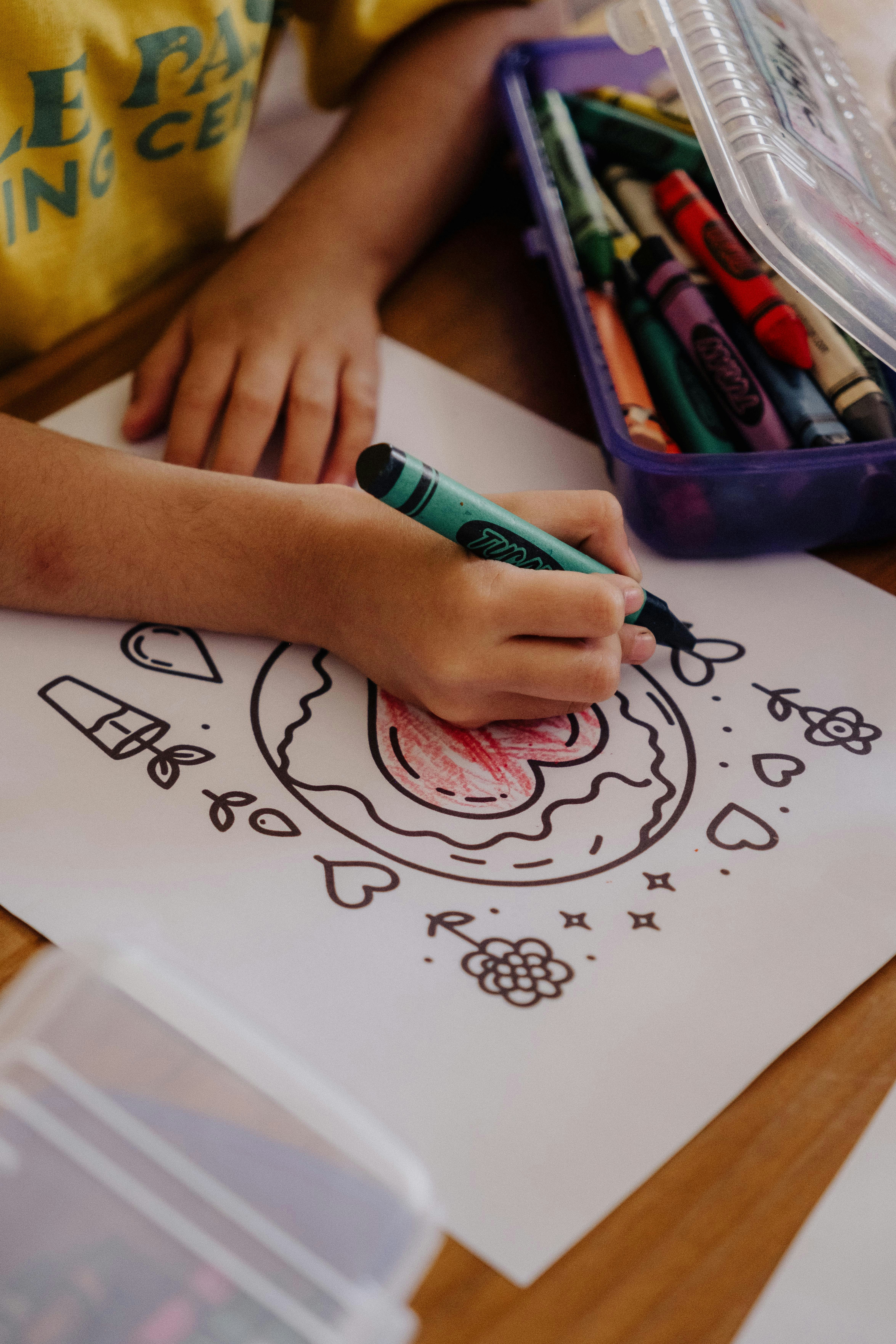 A smiling woman with her arms crossed, standing against a dark green background. She has long, dark hair.