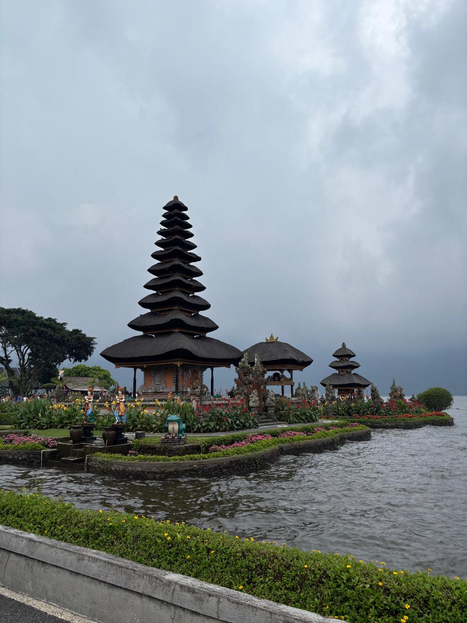 green and brown mountains near body of water under white clouds and blue sky during daytime