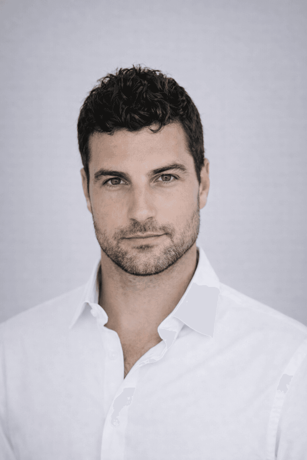 Black and white portrait of a smiling person with curly hair