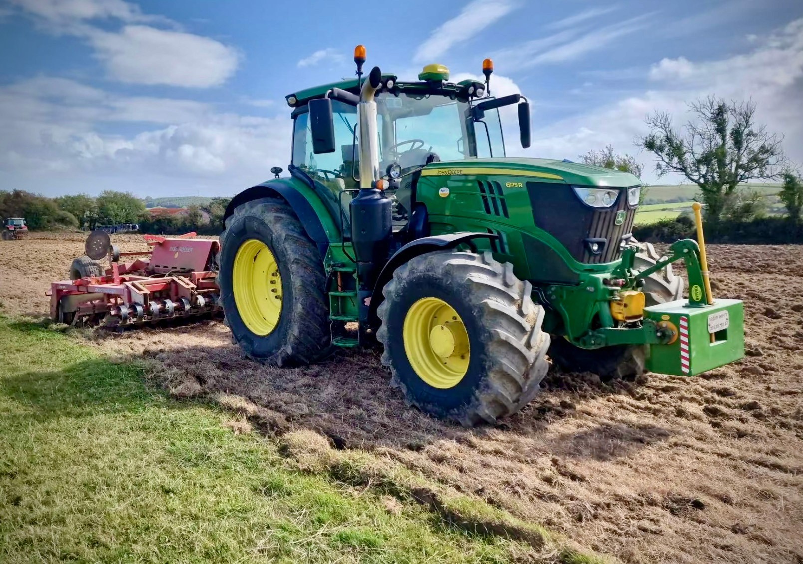 Green and yellow weight block attached to a Green John Deere working in a field