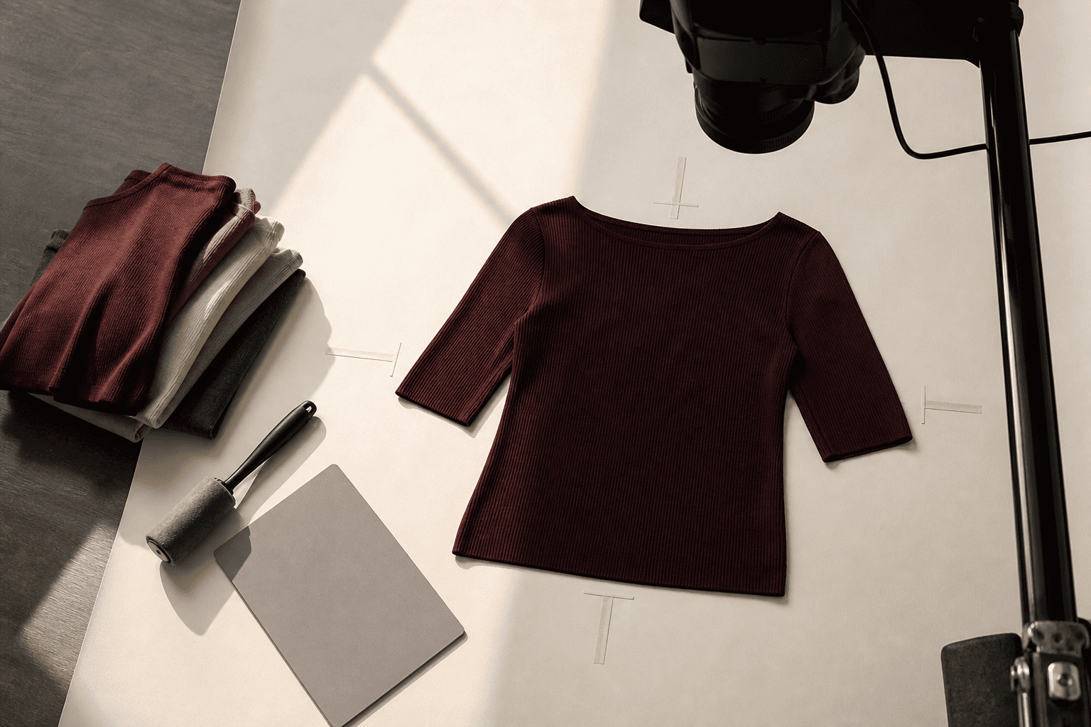 Oxblood knit garment on an overhead set with a neutral target and lint roller