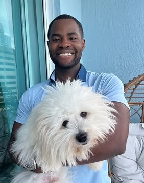 Herby holding his white colored dog named Butter