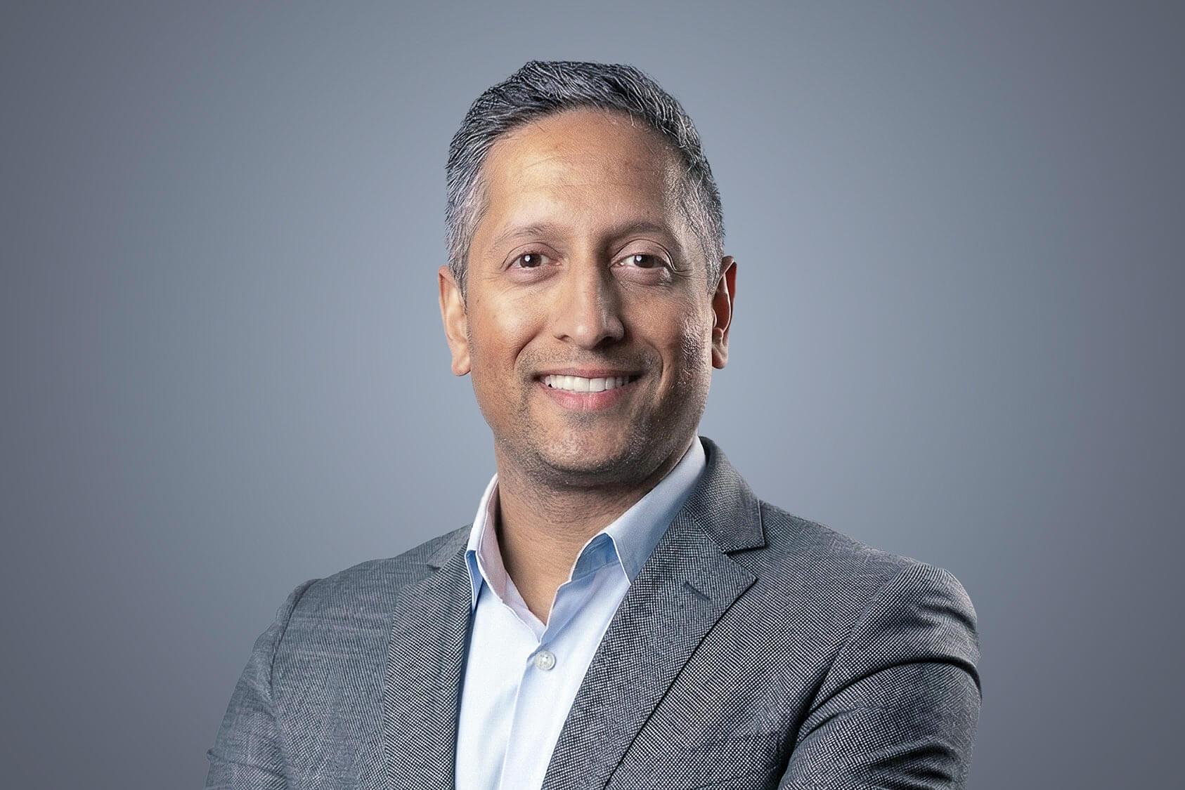 Ritesh Acharya, SteriMax Chief Scientific Officer: Smiling in professional business attire against a neutral studio background.