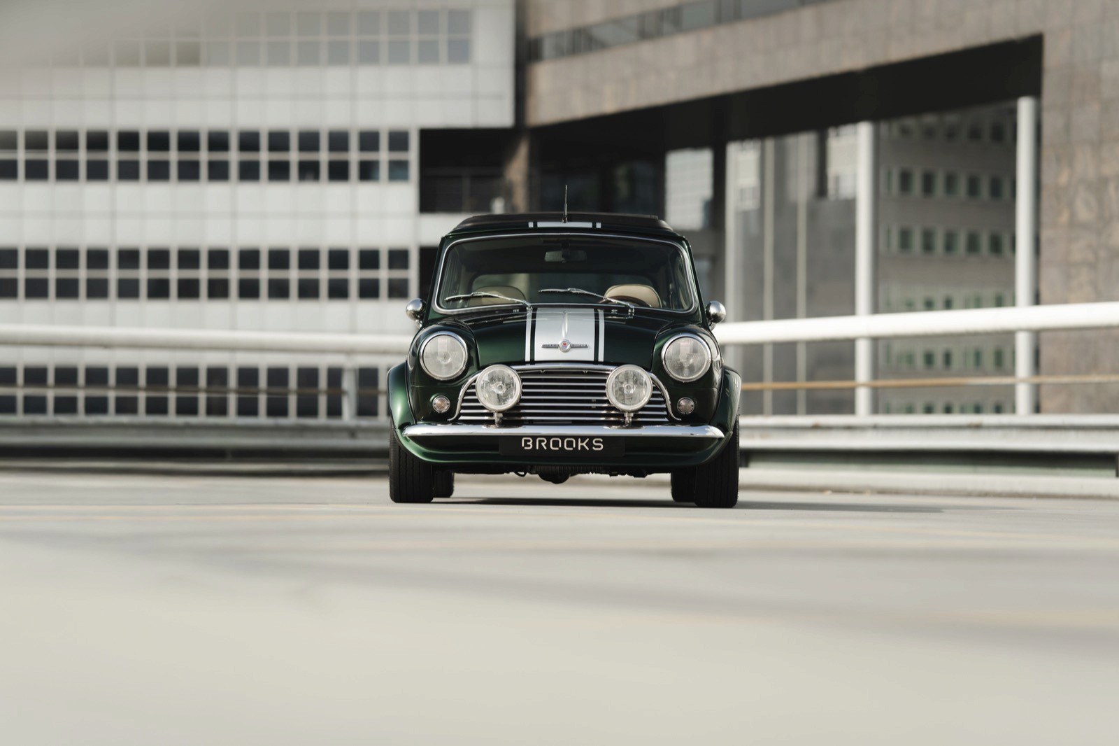 Vintage green Mini Cooper with white stripes and chrome accents.