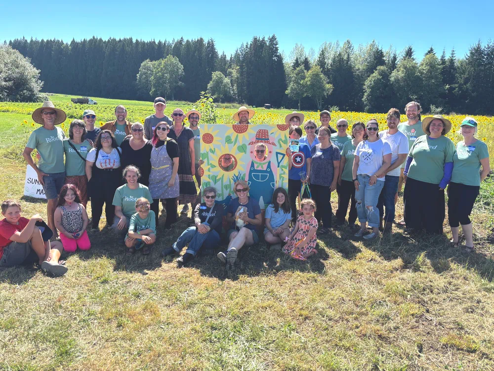 An outdoor gathering area with chairs and a fire pit set in open land at Rooted Northwest.